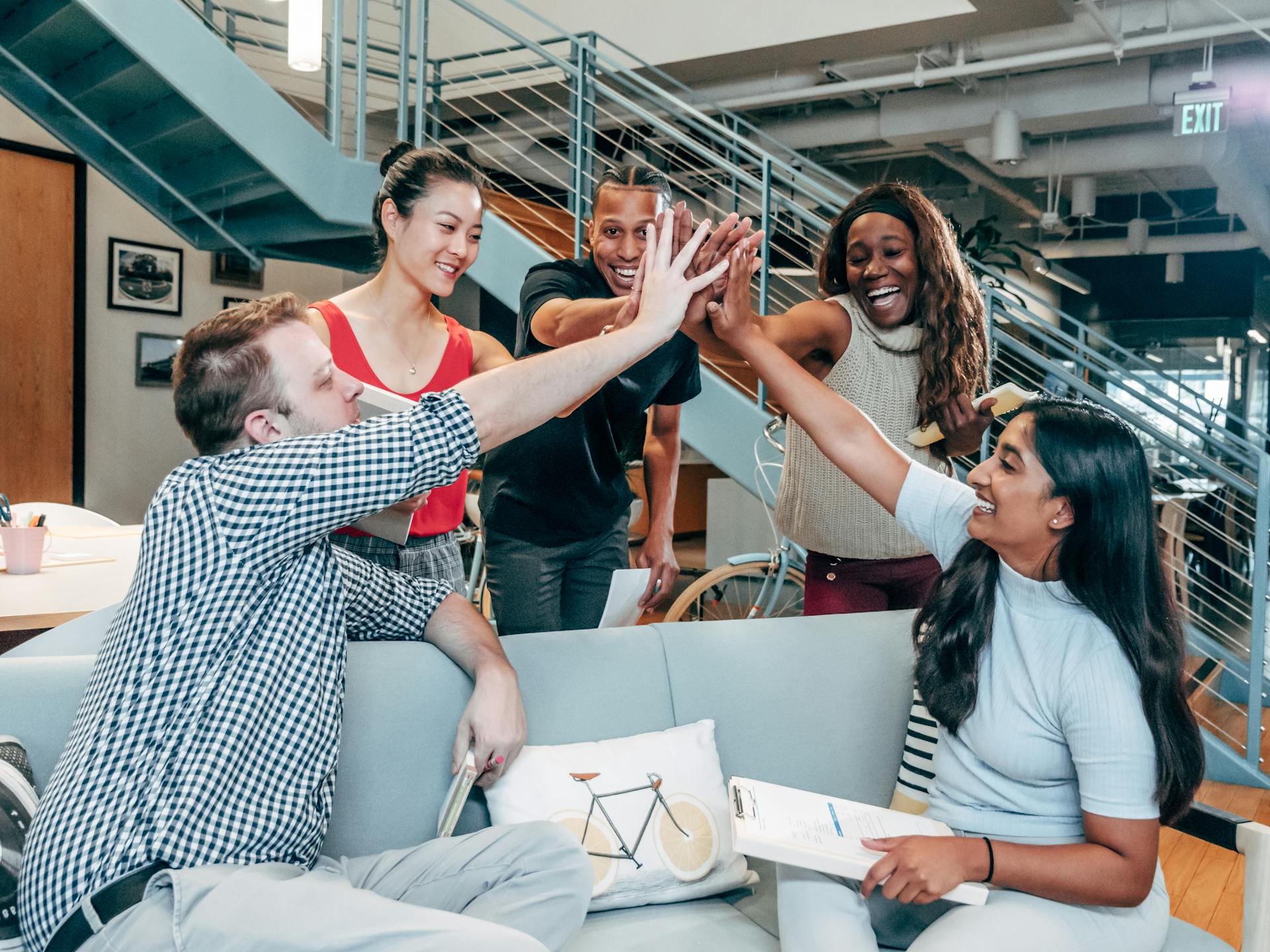 Office workers doing a high five | Source: Pexels