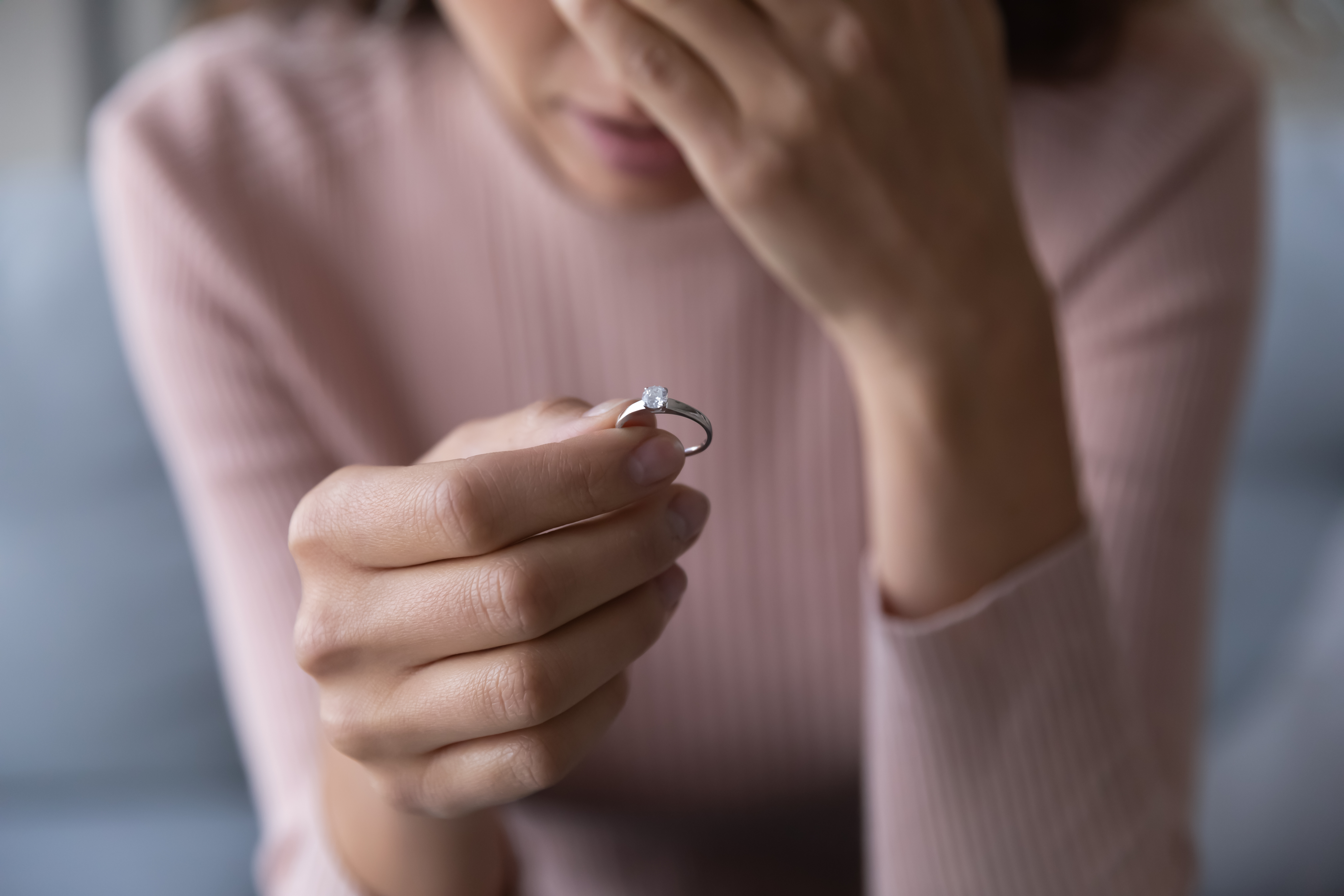 A sad woman holding a ring | Source: Shutterstock