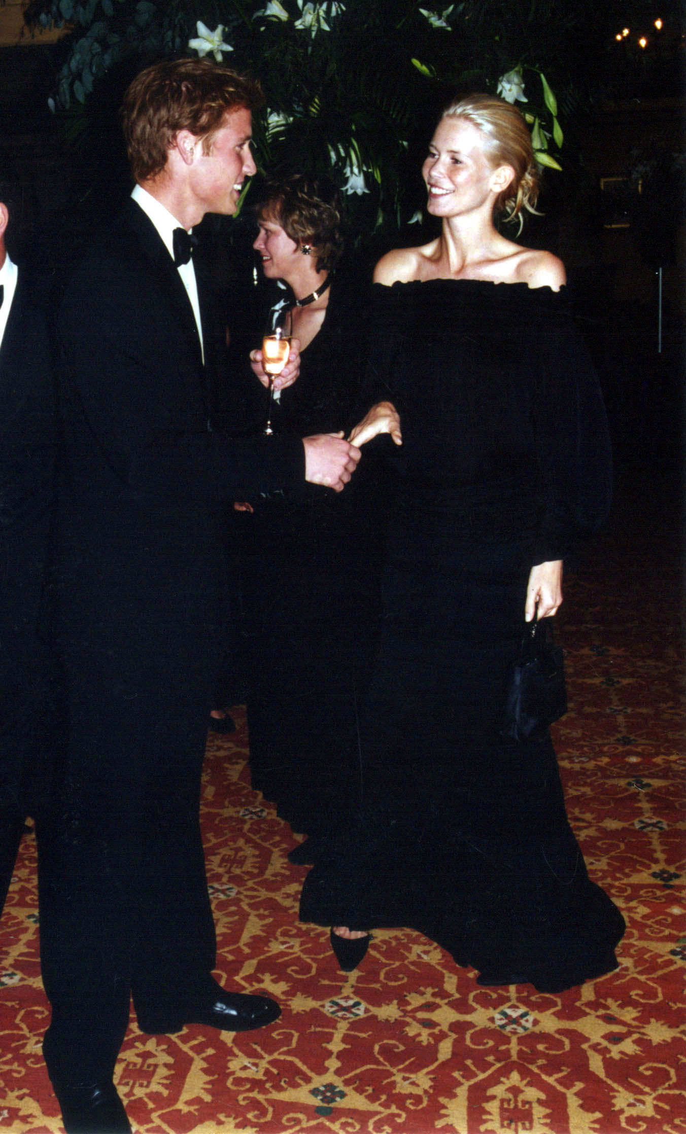 Sharing a light-hearted moment, Prince William and Claudia Schiffer were photographed exchanging greetings at Highgrove House on August 3, 2001. The supermodel, dressed in a sleek off-the-shoulder black gown, offered a warm smile during their reunion at the exclusive soirée.