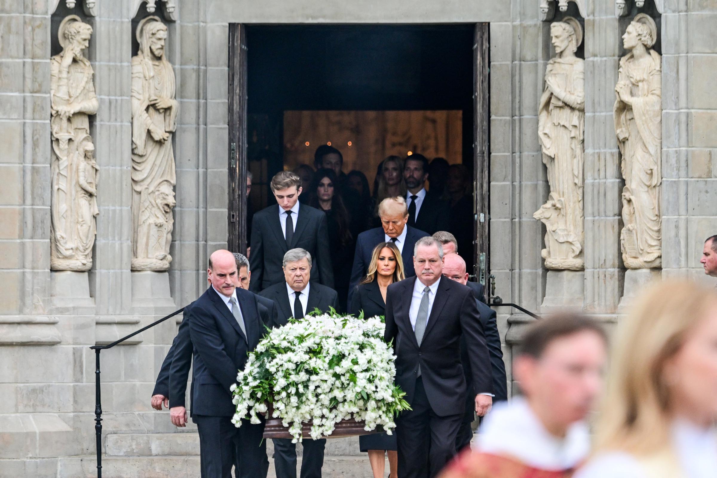 Viktor Knavs walks behind the casket carrying his late wife, Amalija Knavs, as the family leaves the church following the funeral service. Surrounded by Melania Trump, Donald Trump, and Barron Trump, the procession reflected the close family support that has continued through his rare public appearances since her death. | Source: Getty Images