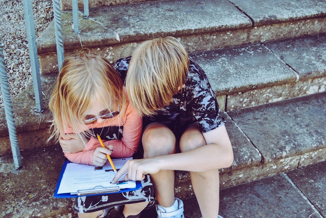 Two children reading a book | Source: Unsplash