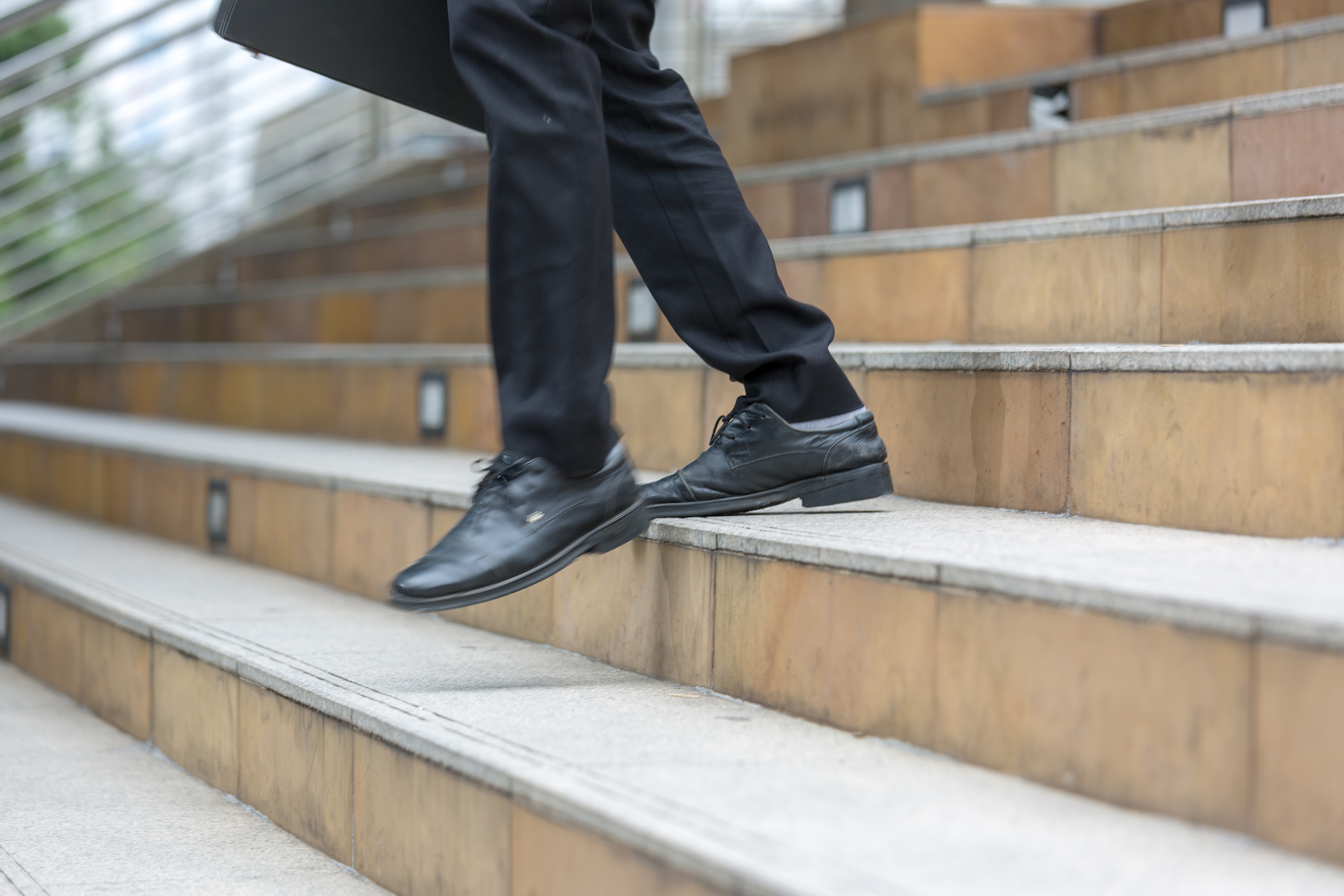 Bussiness person walk downstair in hurry movement. | Source: Shutterstock