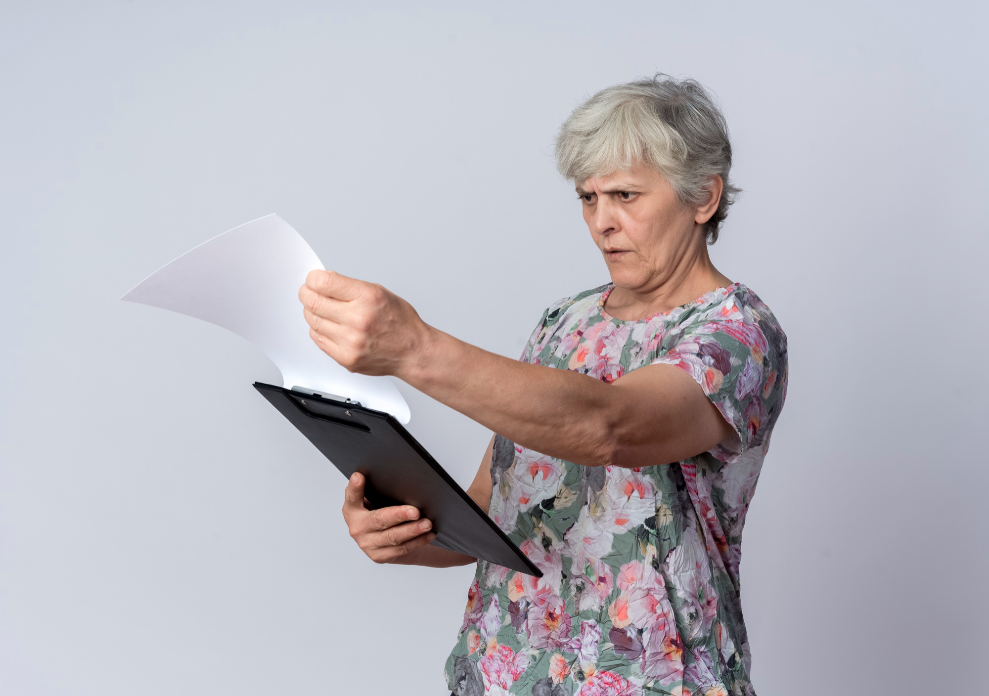 An upset older woman reading some paperwork | Source: Pexels