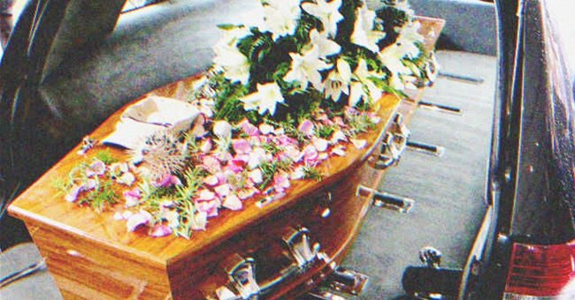 A coffin covered in flowers in a hearse | Source: Shutterstock