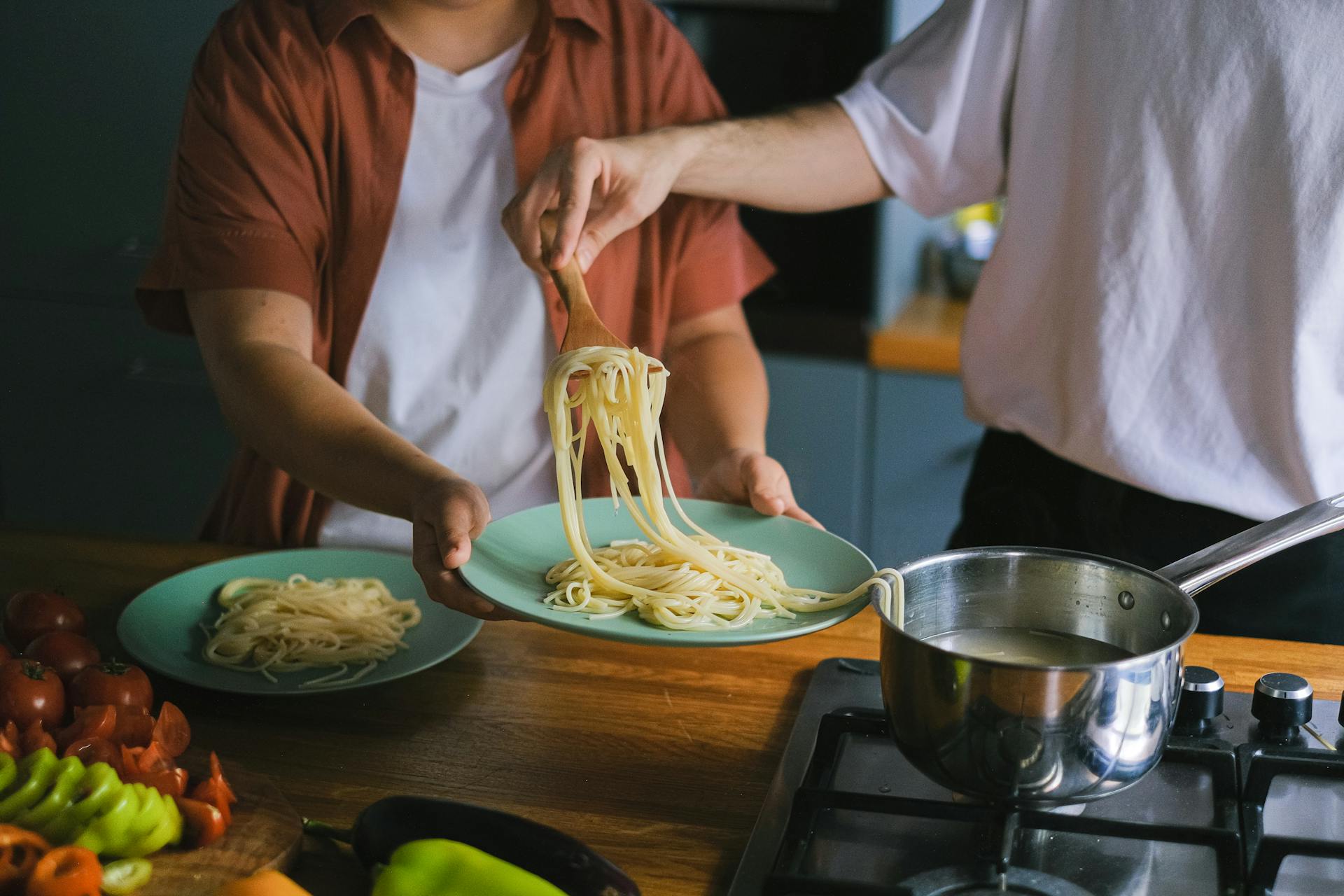 A man taking out cooked spaghetti from a pan | Source: Pexels