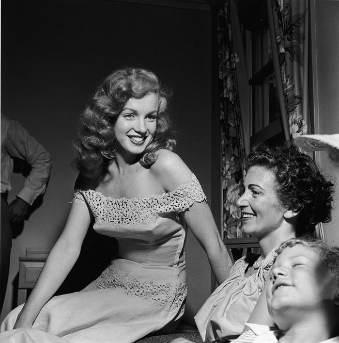 Marilyn Monroe presents Photoplay Magazine's 'Dream House' contest winner Virginia McAllister and her son with the key to a new house, Warrenburg, New York, June 1949 I Photo: Getty Images