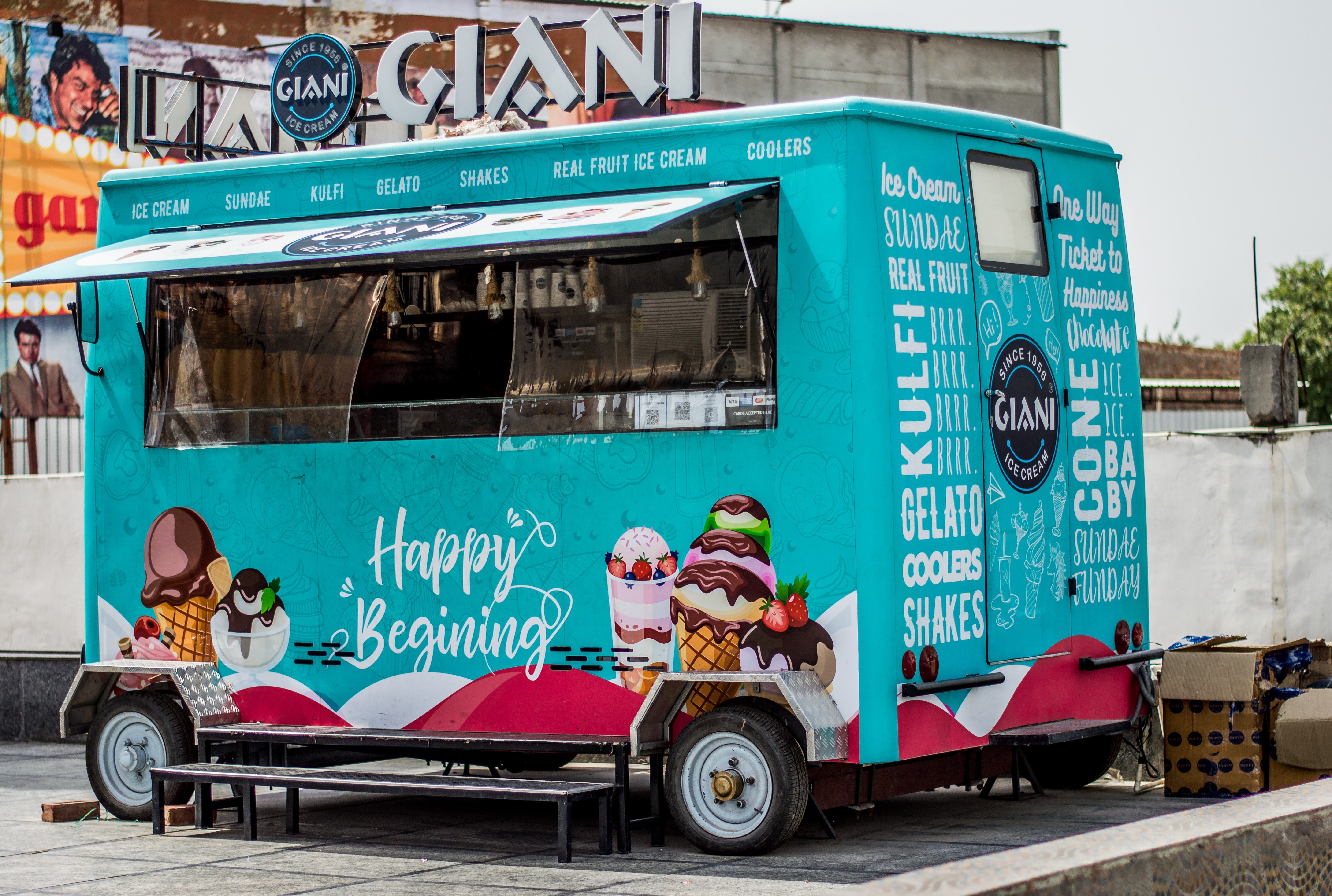 A blue ice cream truck with the words 'Happy Beginning' painted on the side is open for business | Photo: Pexels/Prithpal Bhatia 