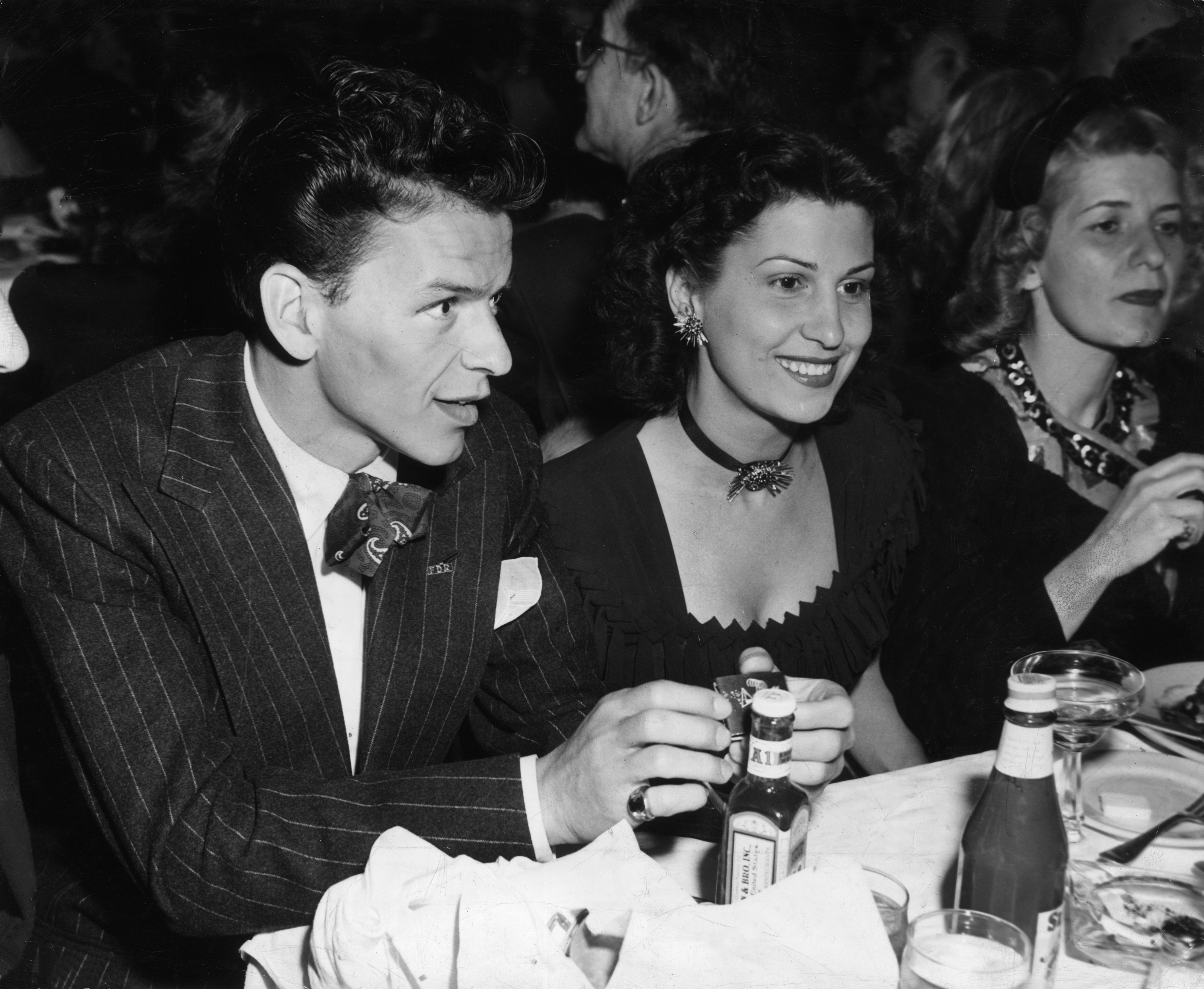 Frank Sinatra sitting in a nightclub next to his first wife, Nancy Barbato | Source: Getty Images