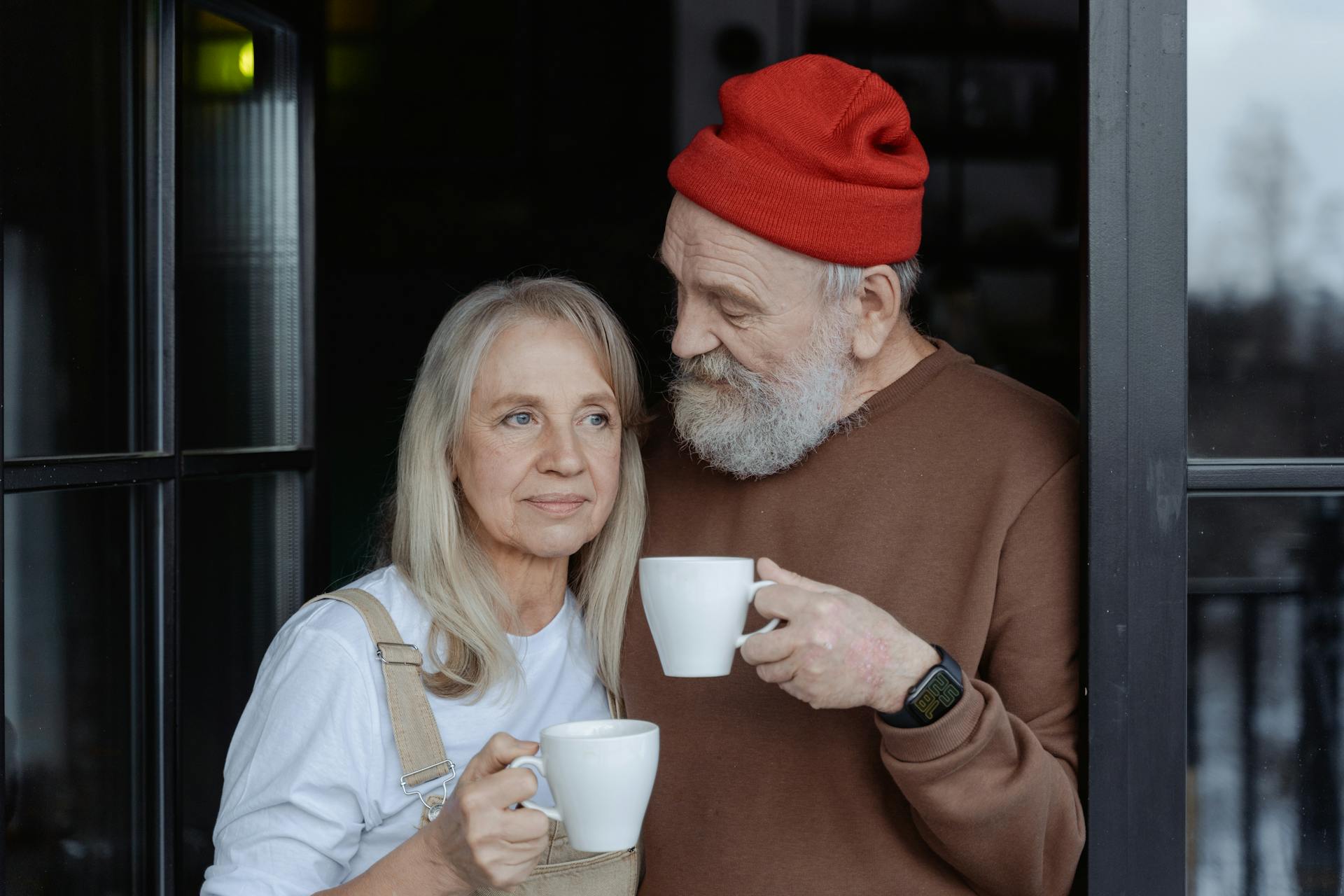 An older couple holding white ceramic mugs | Source: Pexels