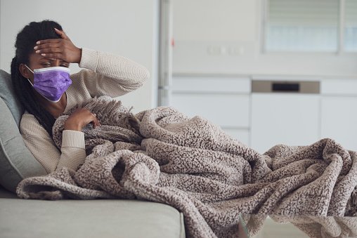 Jeune femme malade se tenant la main sur le front. | Photo : Getty Images