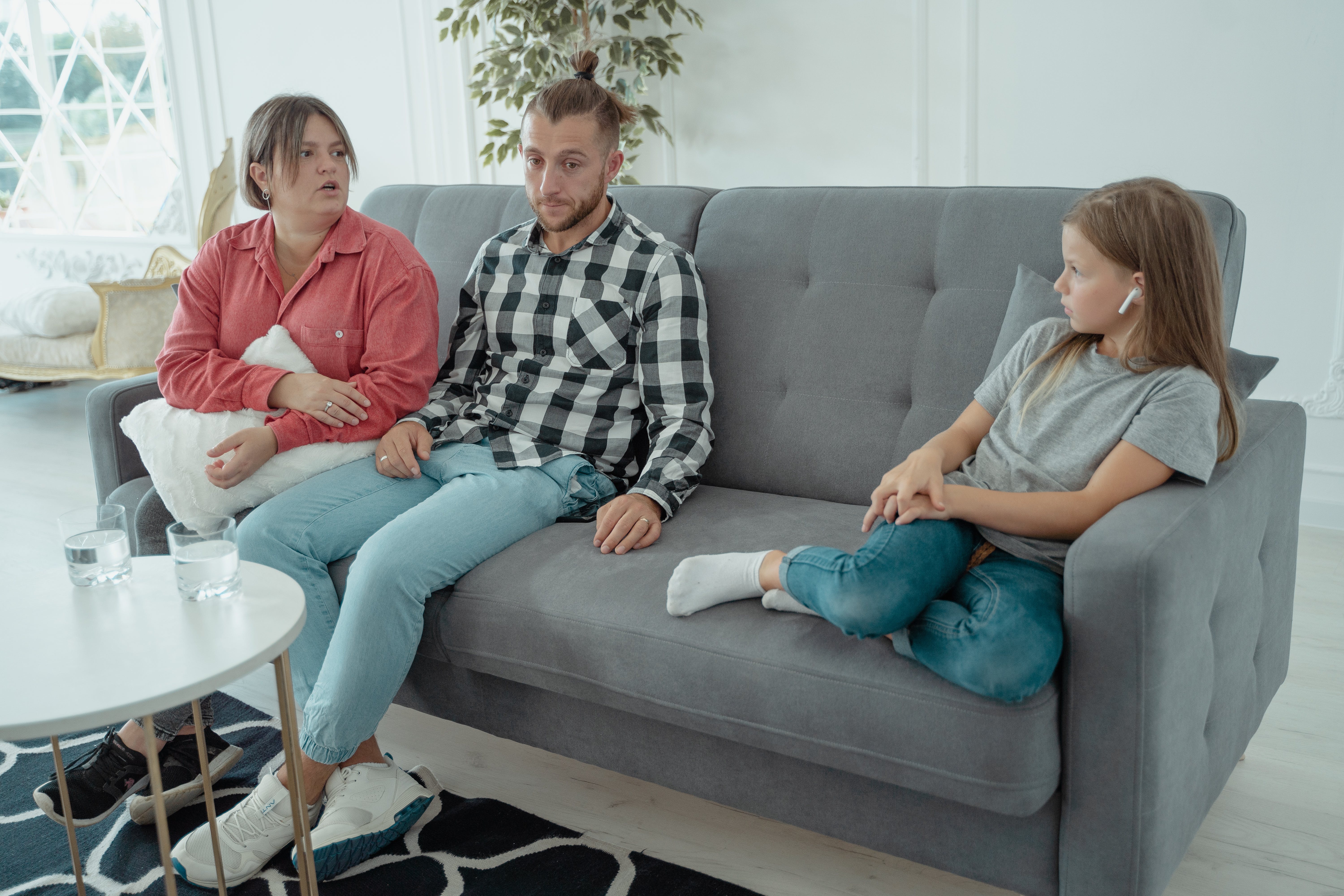 A family sitting on a couch | Source: Pexels