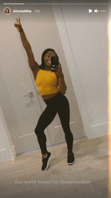 A mirror selfie of Simone Biles showing off her navel piercing in a yellow crop top | Photo: Instagram/simonebiles