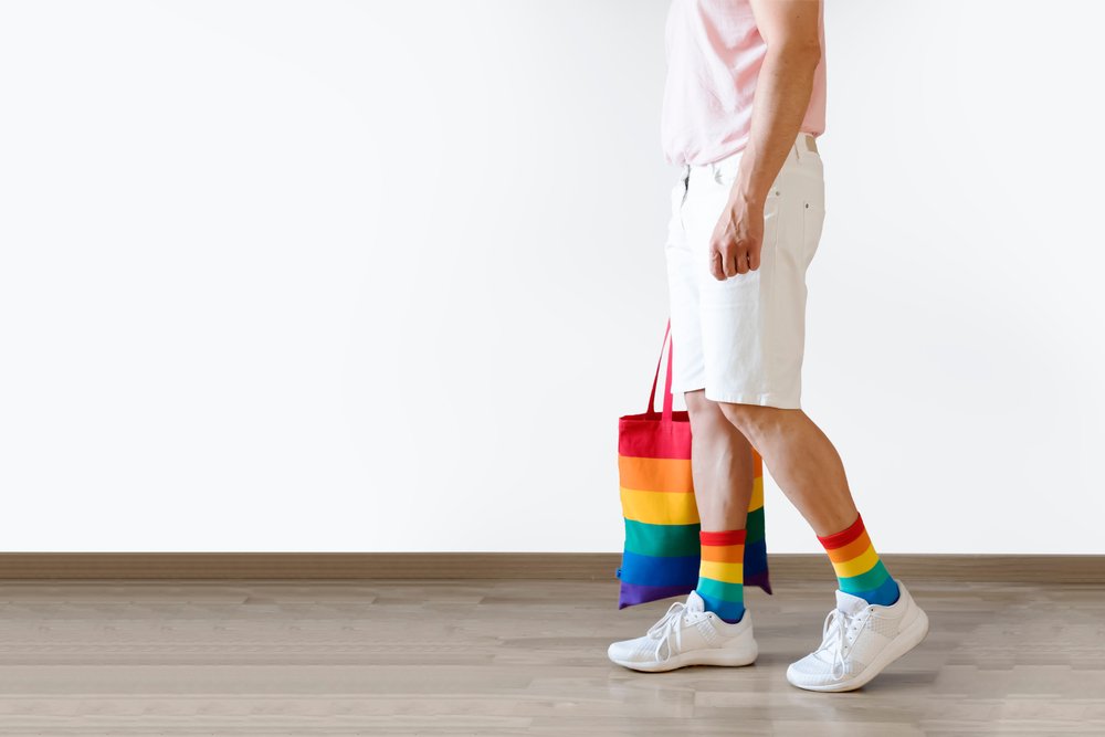 Hombre con medias y bolsos del arco iris gay. | Foto: Shutterstock.