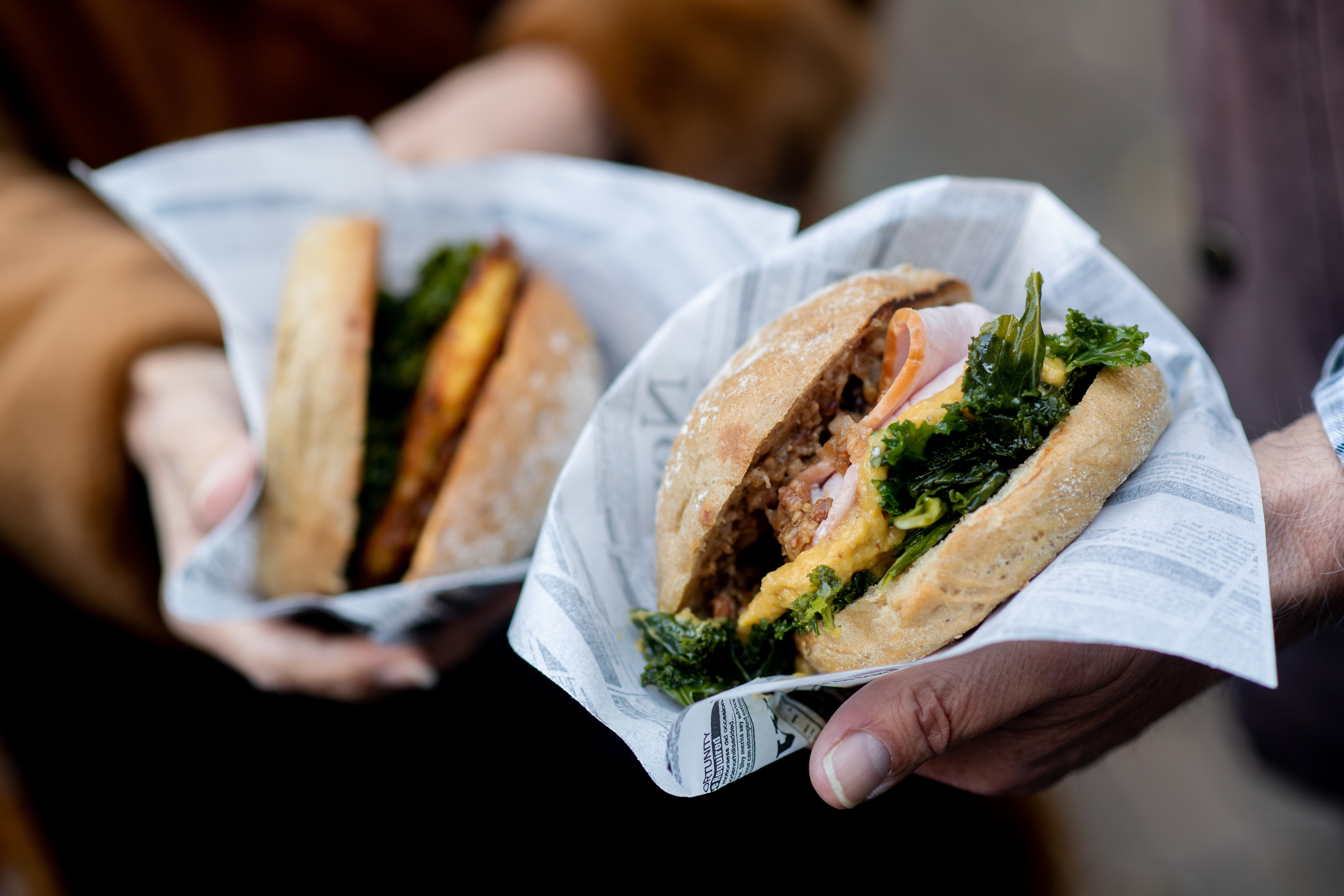 A couple holds two kale burgers in their hands | Source: Getty images