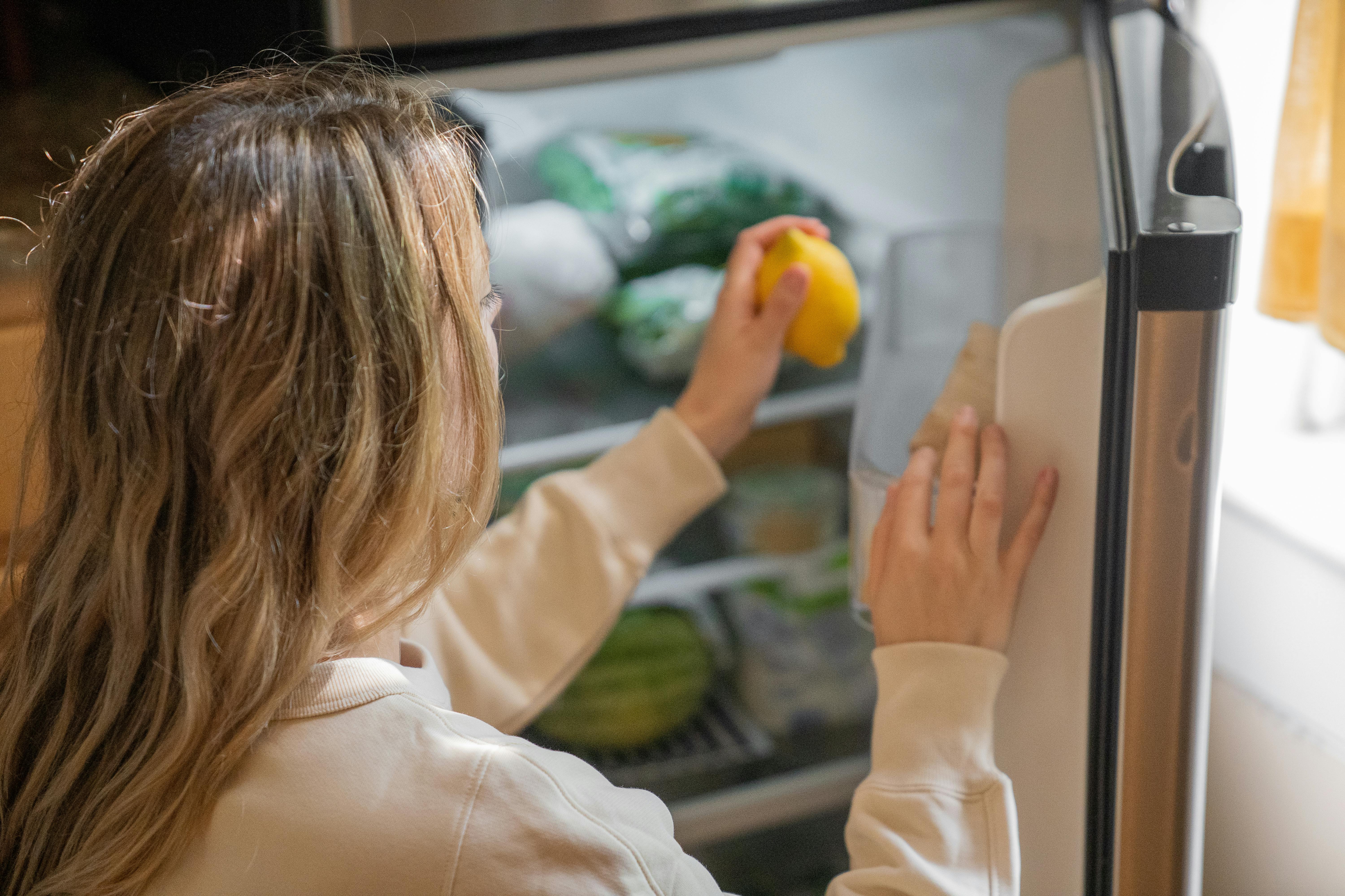 A woman putting food into fridge | Source: Pexels