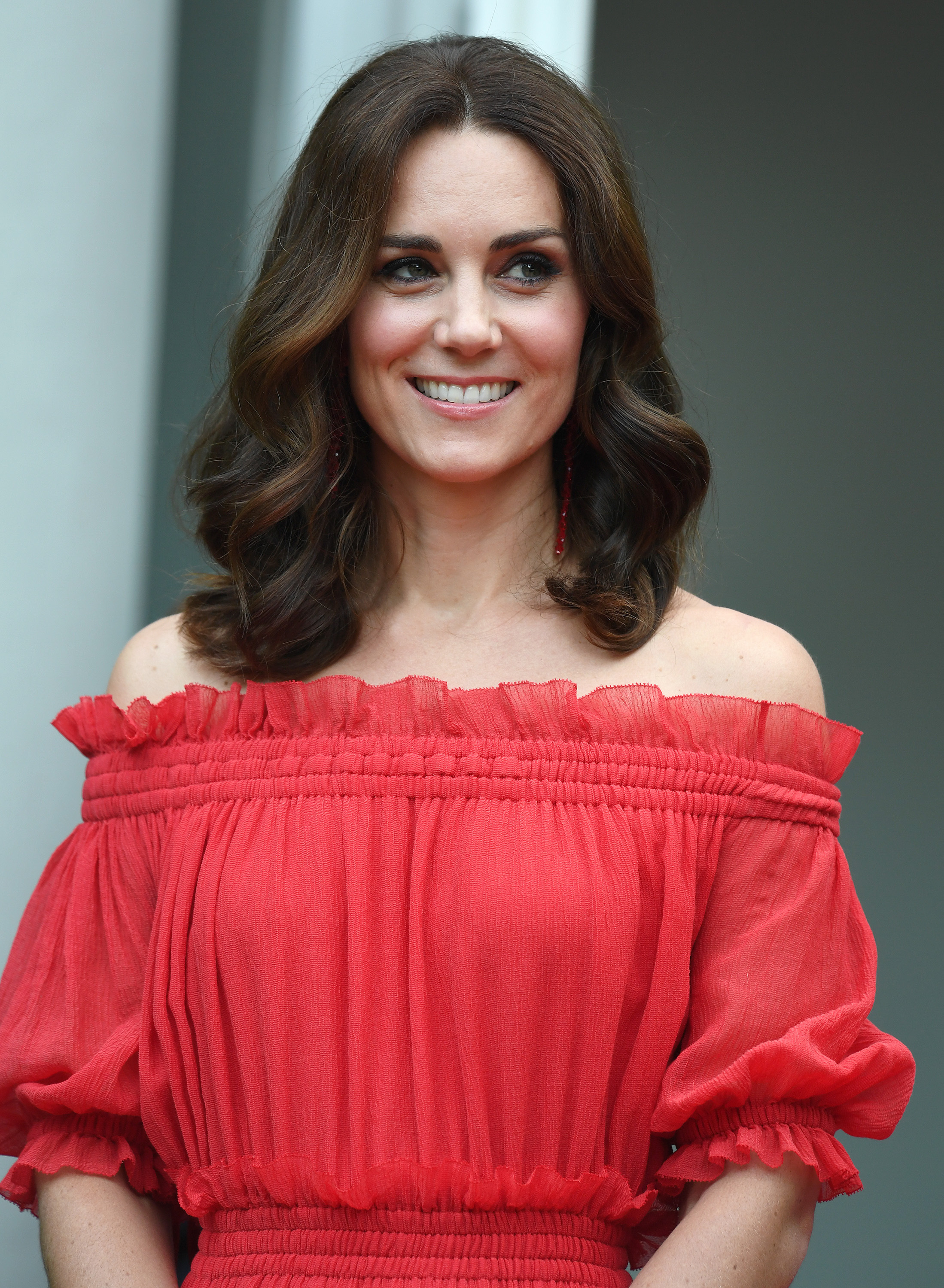 Catherine, Duchess of Cambridge, attends The Queen’s Birthday Party at the British Ambassadorial Residence during her official visit to Poland and Germany. Dressed elegantly and smiling, she styled her hair in soft long waves that created a chic, bob-like effect.