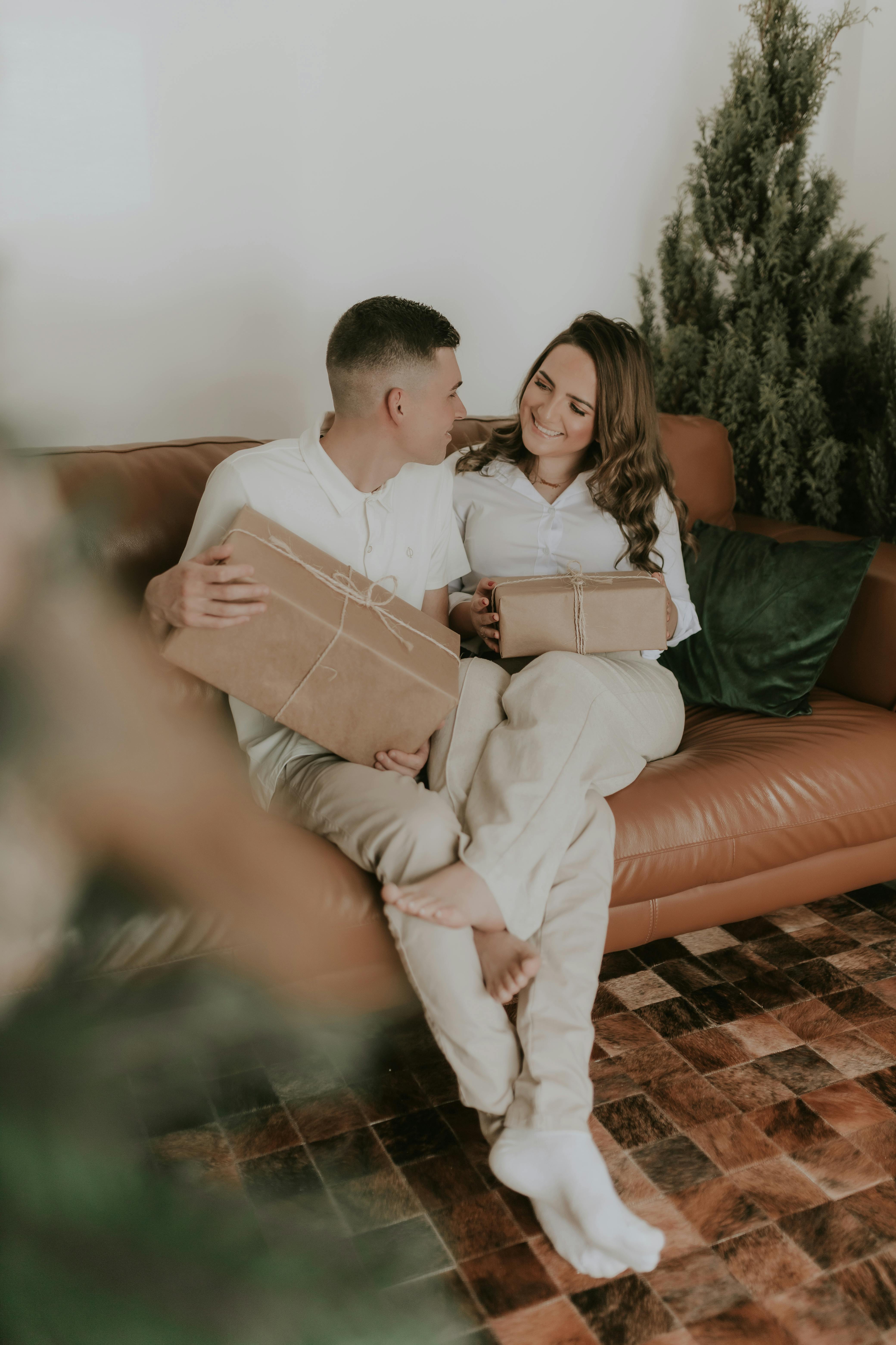 A happy couple sitting with gift boxes | Source: Pexels