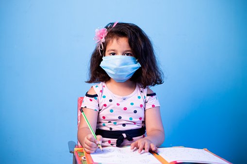 Une fille portant un masque pendant qu'elle fait ses devoirs. | Photo : Getty Images Une fille portant un masque pendant qu'elle fait ses devoirs. | Photo : Getty Images