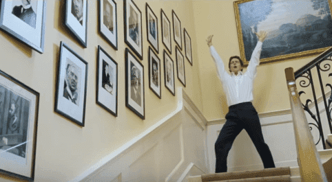 Hugh Grant dancing down the stairs in the film "Love Actually." | Source: YouTube/Movieclips.