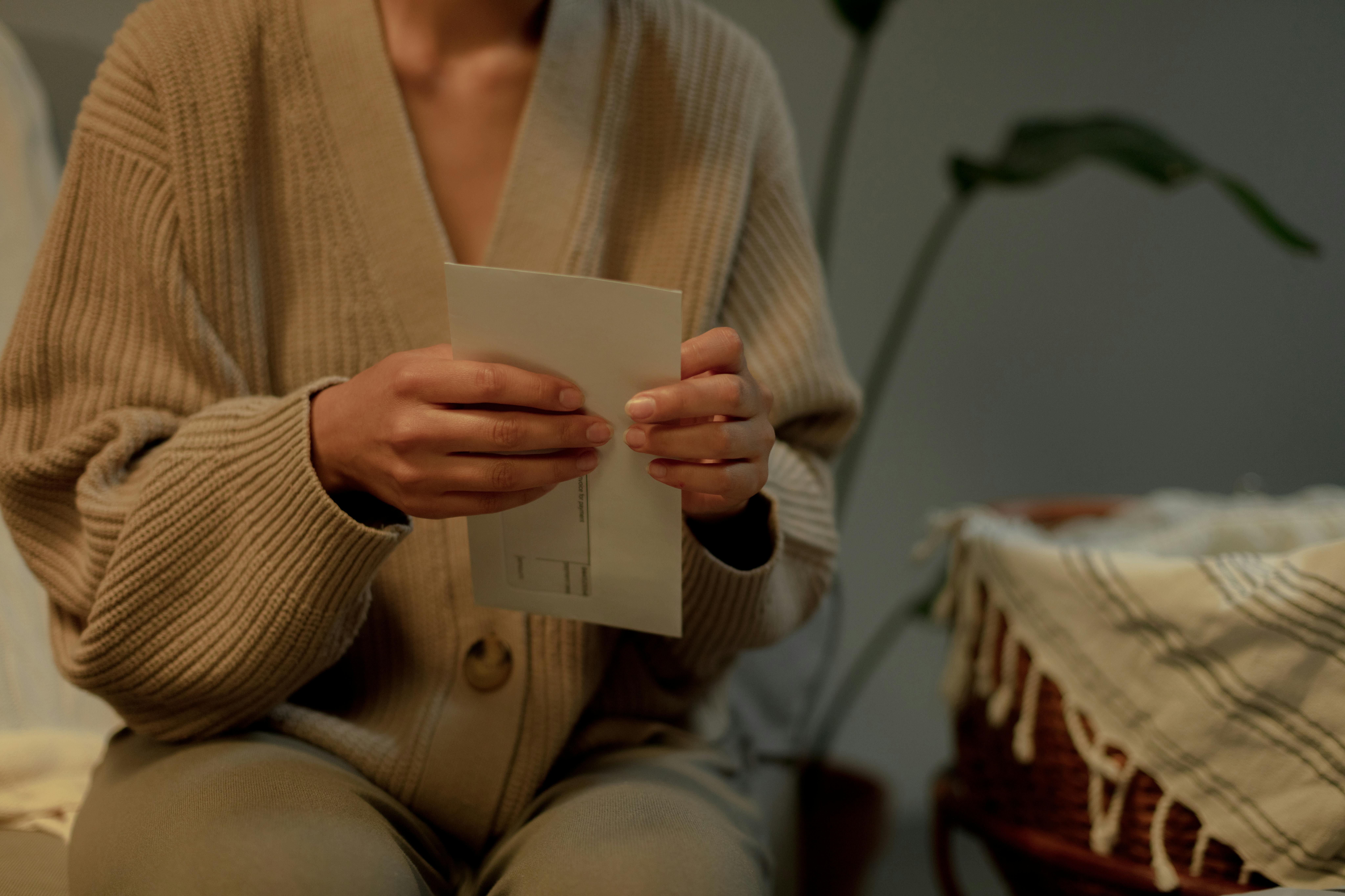 A woman opening an envelope | Source: Pexels