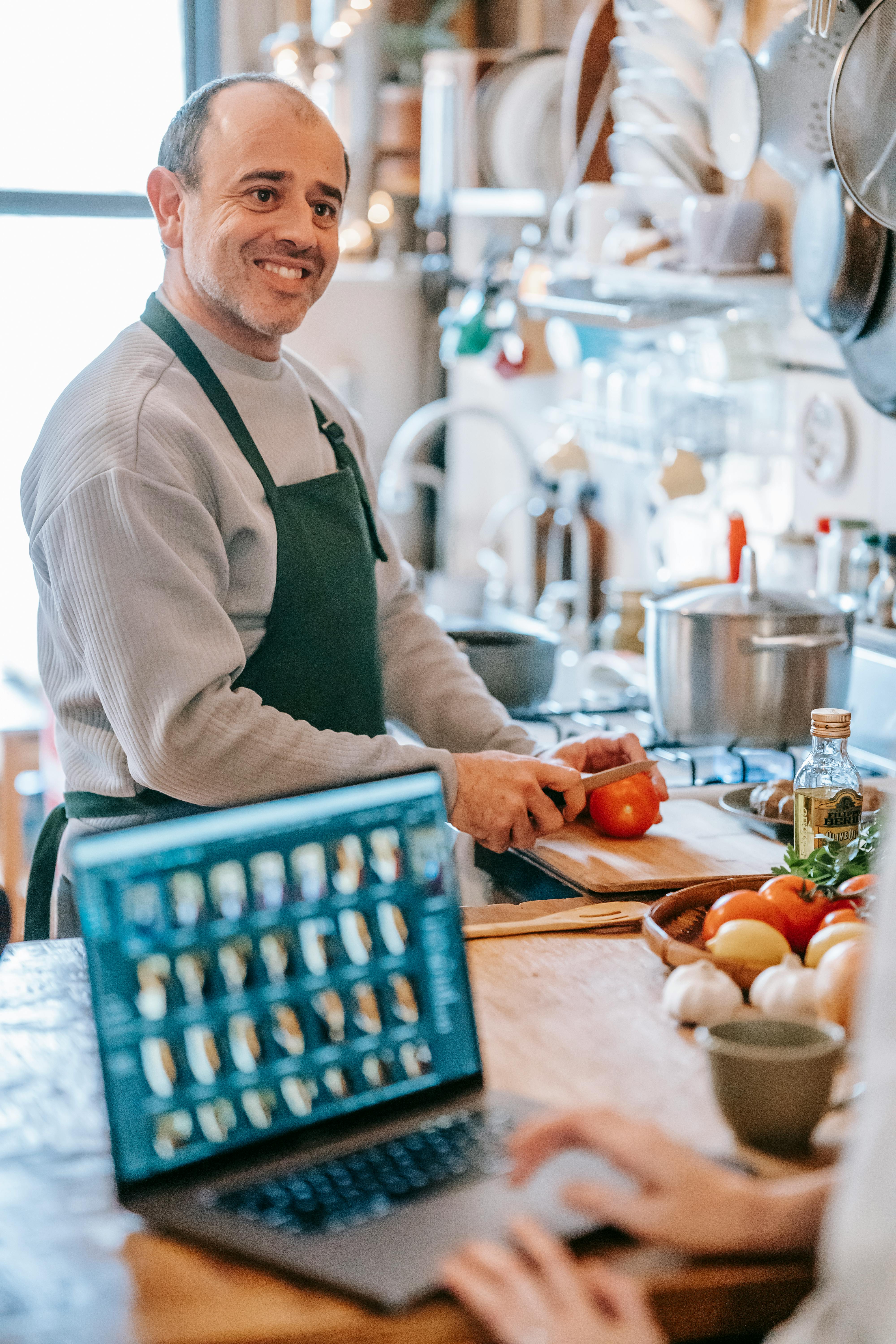 A smiling man preparing a meal | Source: Pexels