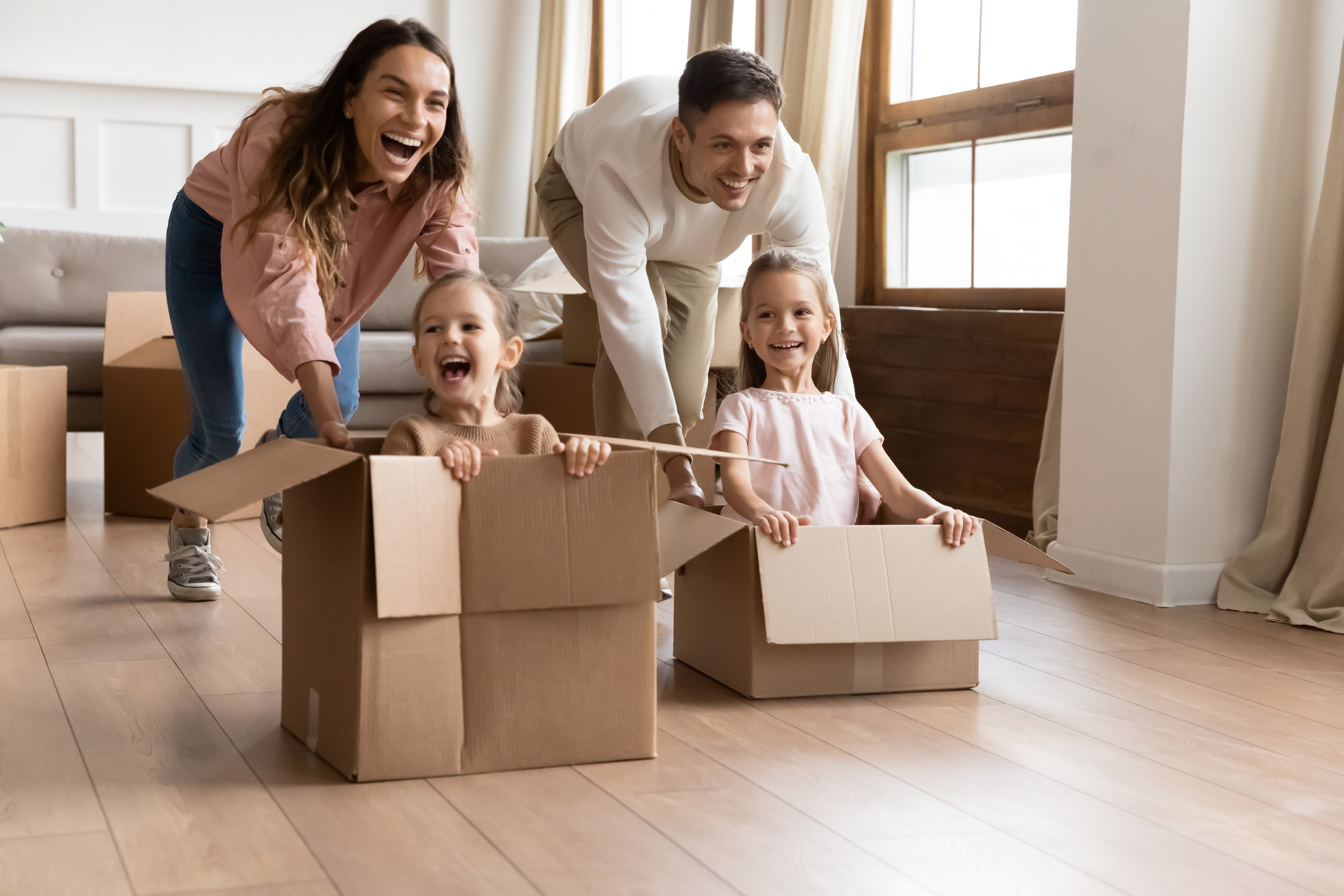 Happy parents playing with children in the living room | Source: Shutterstock