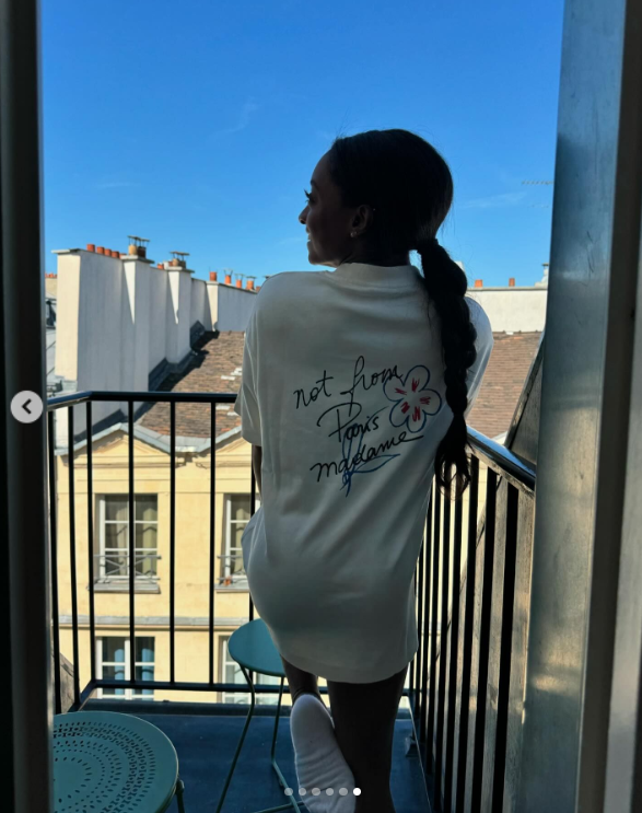 Simone Biles wears an oversized white shirt while looking out from her balcony in Paris, France, posted in August 2024 | Source: Instagram.com/simonebiles