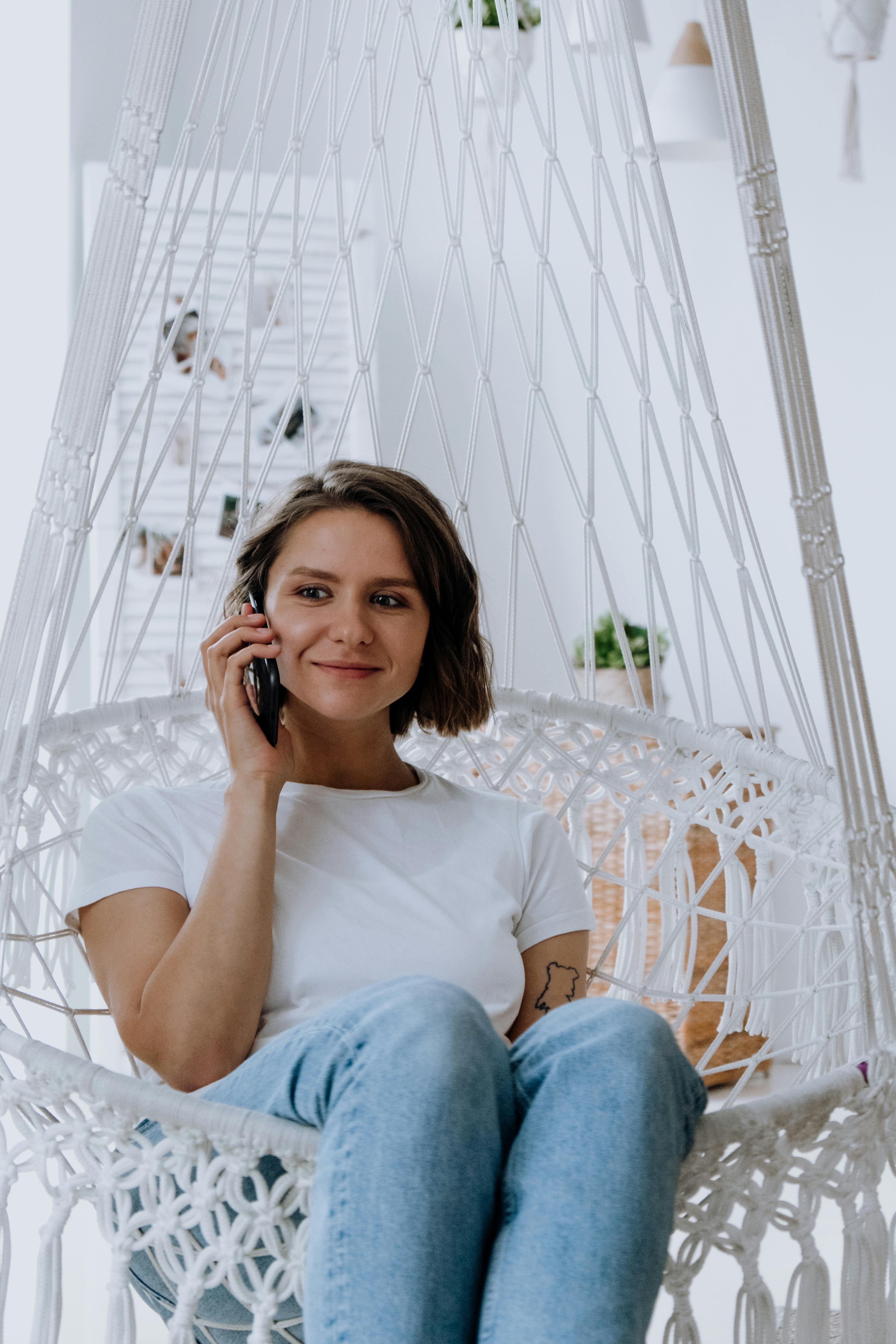 A neutral-looking woman talking to someone on the phone | Source: Pexels