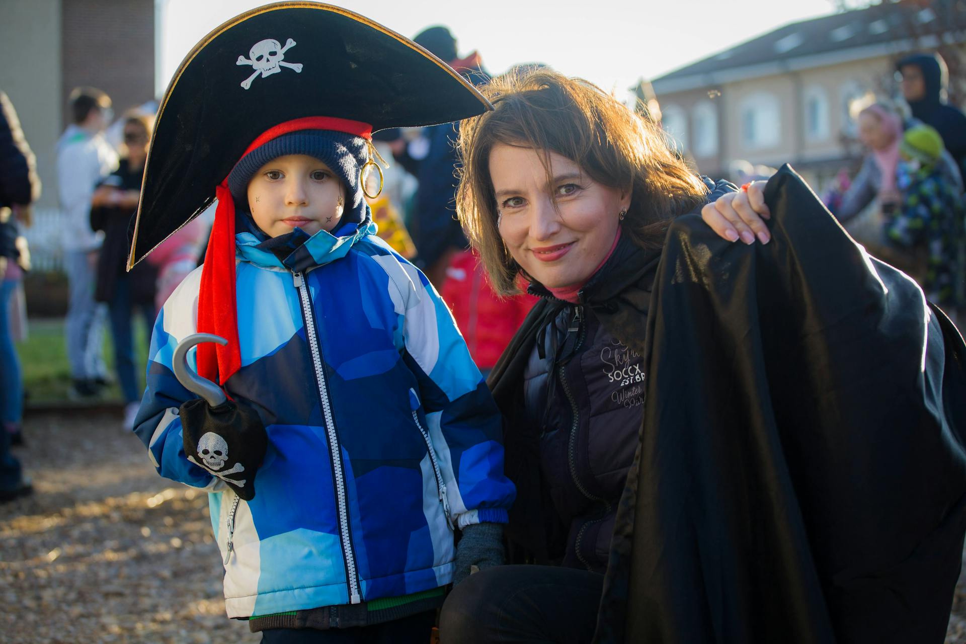 A little boy in a pirate costume standing with his mother | Source: Pexels