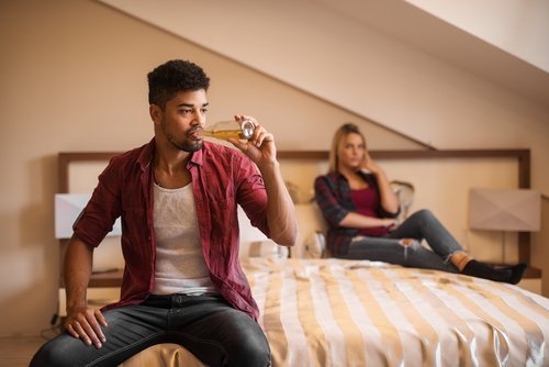 Couple fighting while man is drinking alcohol. | Source: Shutterstock.