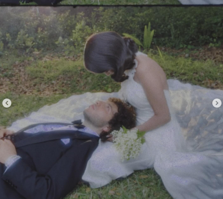 Selena Gomez looks down at Benny Blanco as he lies on the grass during a wedding photoshoot, as posted on September 27, 2025 | Source: Instagram/selenagomez