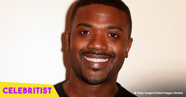 Ray J holds baby daughter as she rocks her curly hair with white bow & purple tracksuit in pic