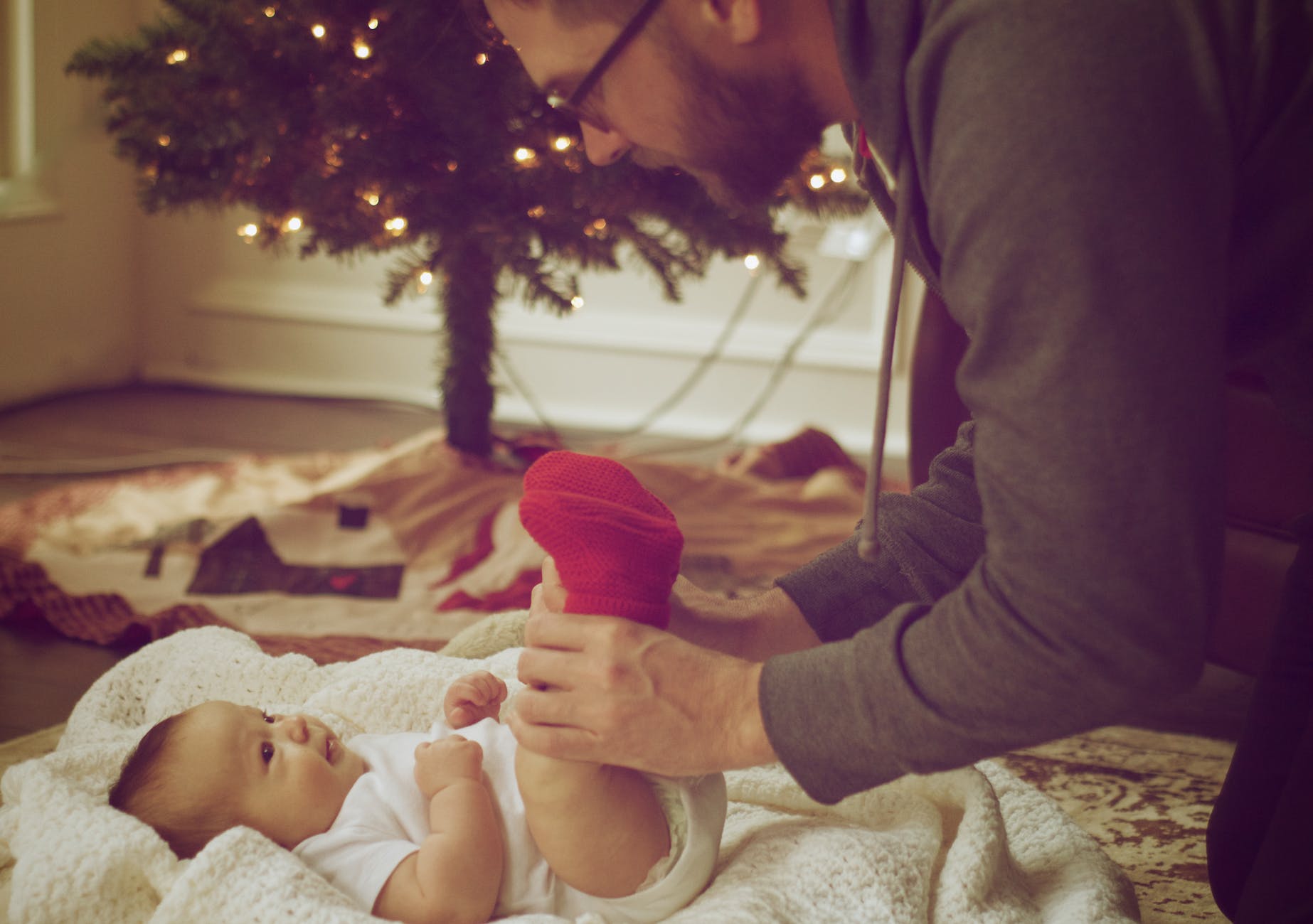 A photo of a doting father taking care of his child and changing diapers. | Photo: Pexels