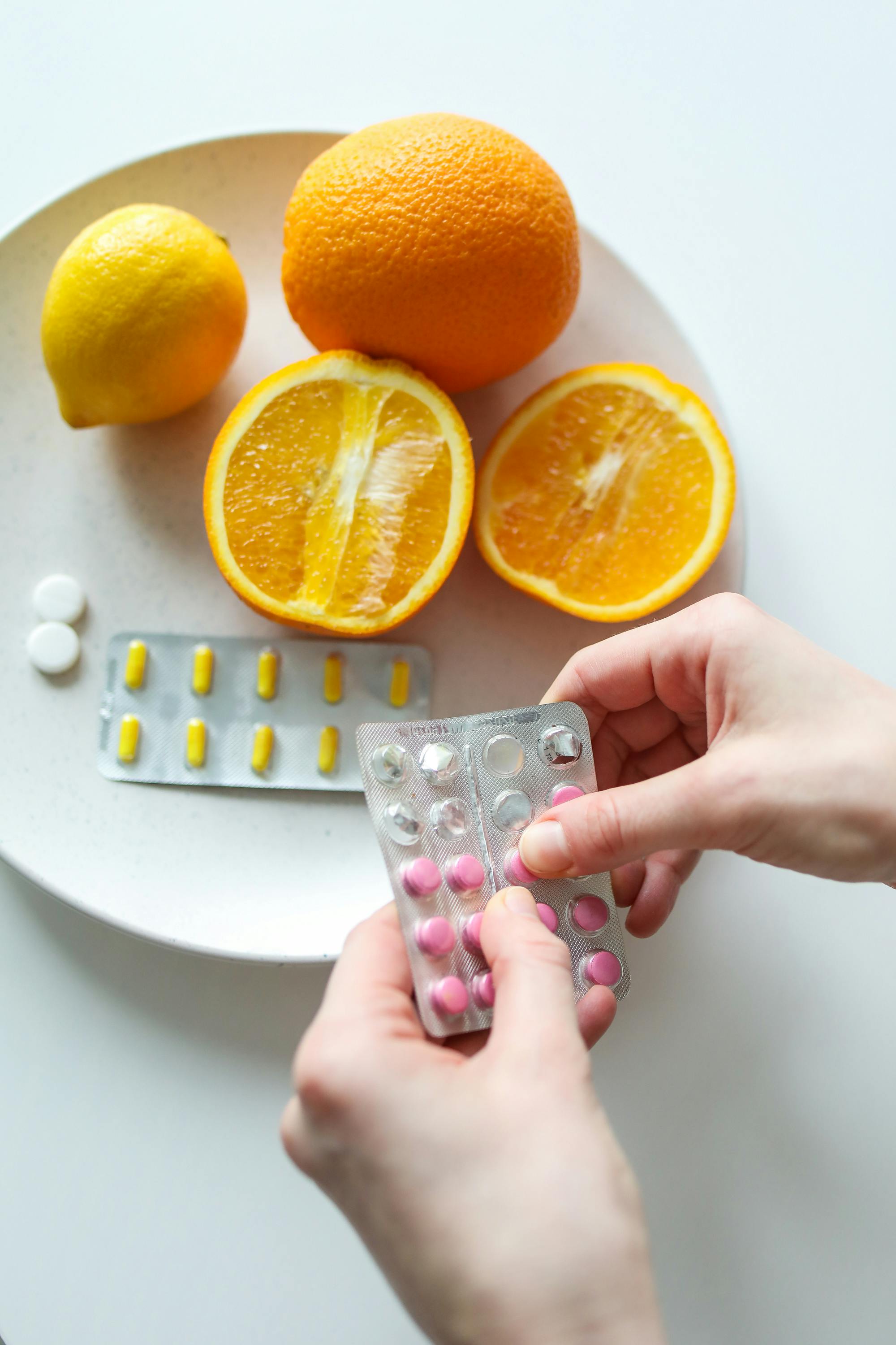 Vitamin pills and oranges | Source: Pexels