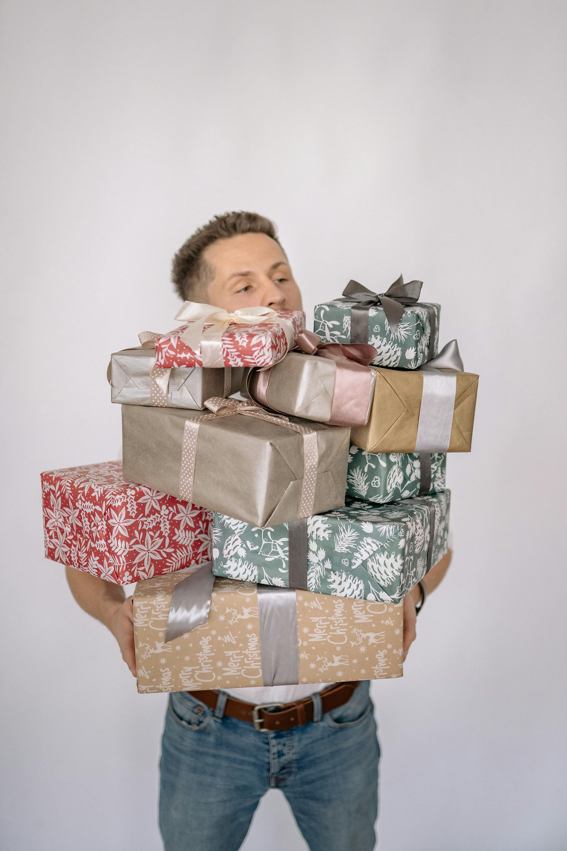 A man holding a pile of gift boxes | Source: Pexels