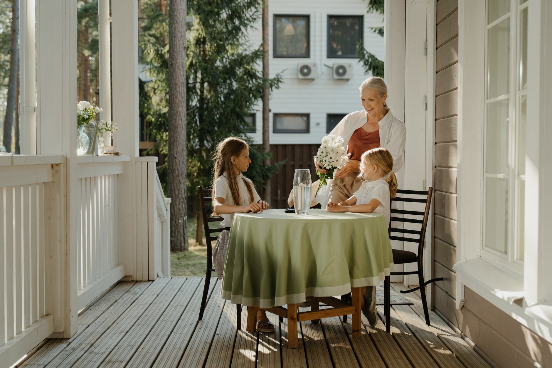 Abuela y nietas sentadas al aire libre. | Foto: Pexels