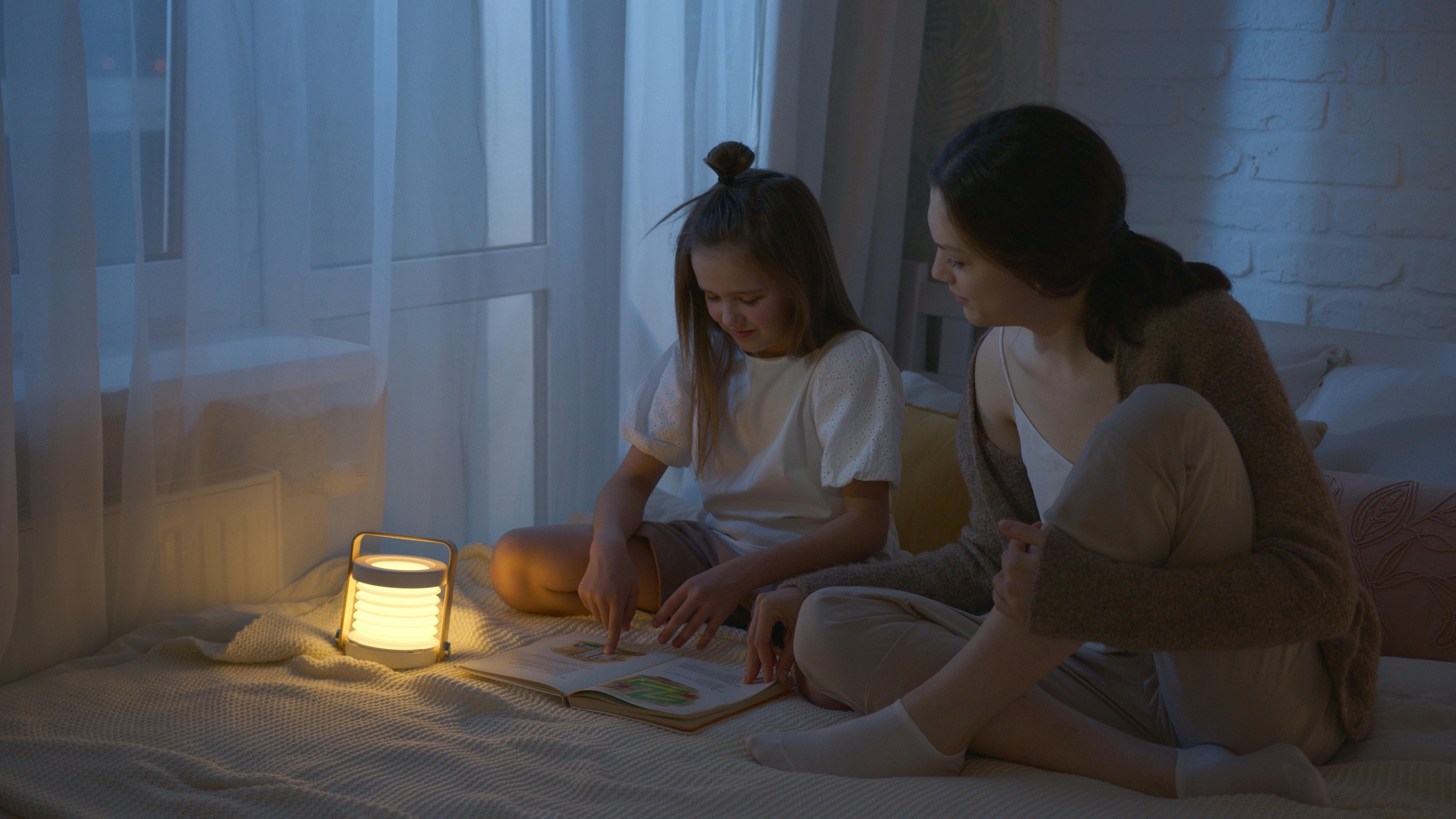 A woman and a girl sitting on the bed with a book | Source: Pexels