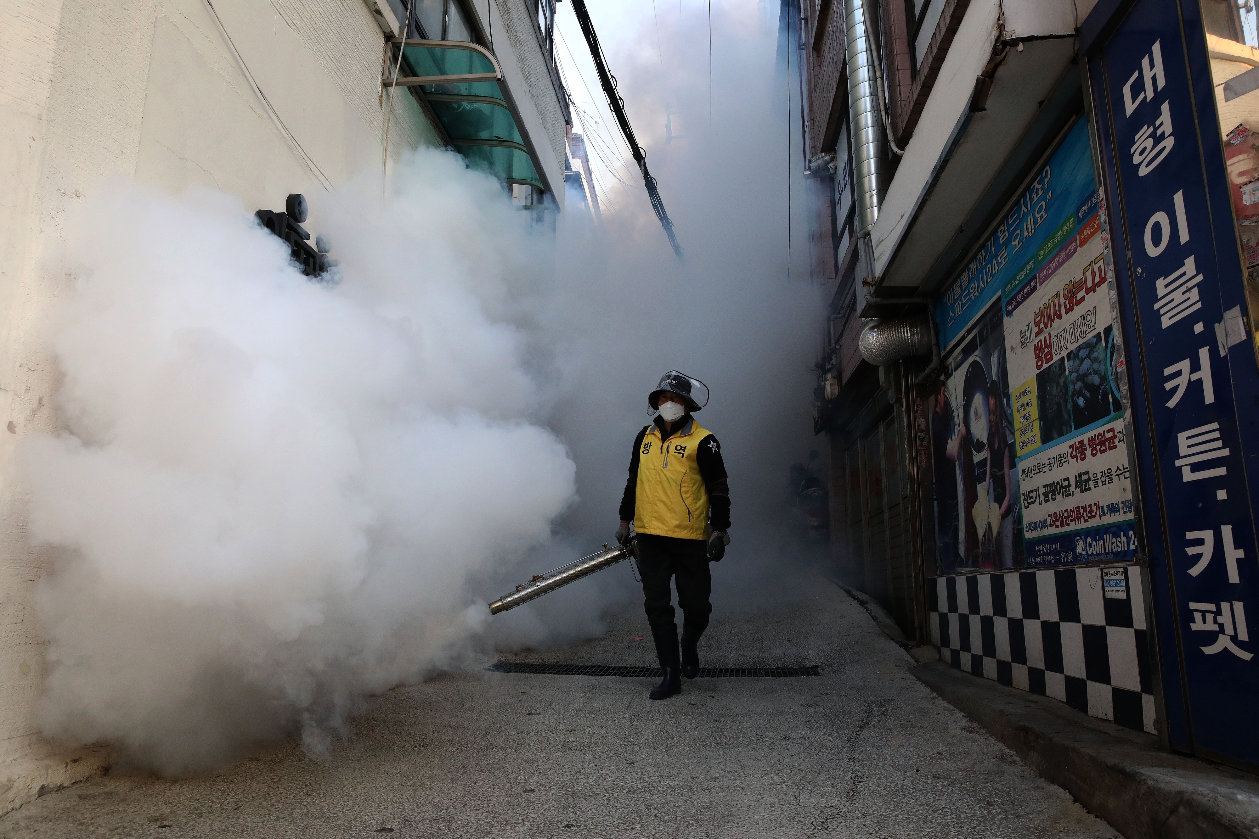 Un hombre surcoreano desinfecta un callejón para evitar la propagación del coronavirus (COVID-19) el 18 de marzo de 2020 en Seúl, Corea del Sur. Según el Centro de Corea para el Control y Prevención de Enfermedades el viernes, se reportaron 93 nuevos casos. | Foto: Getty Images