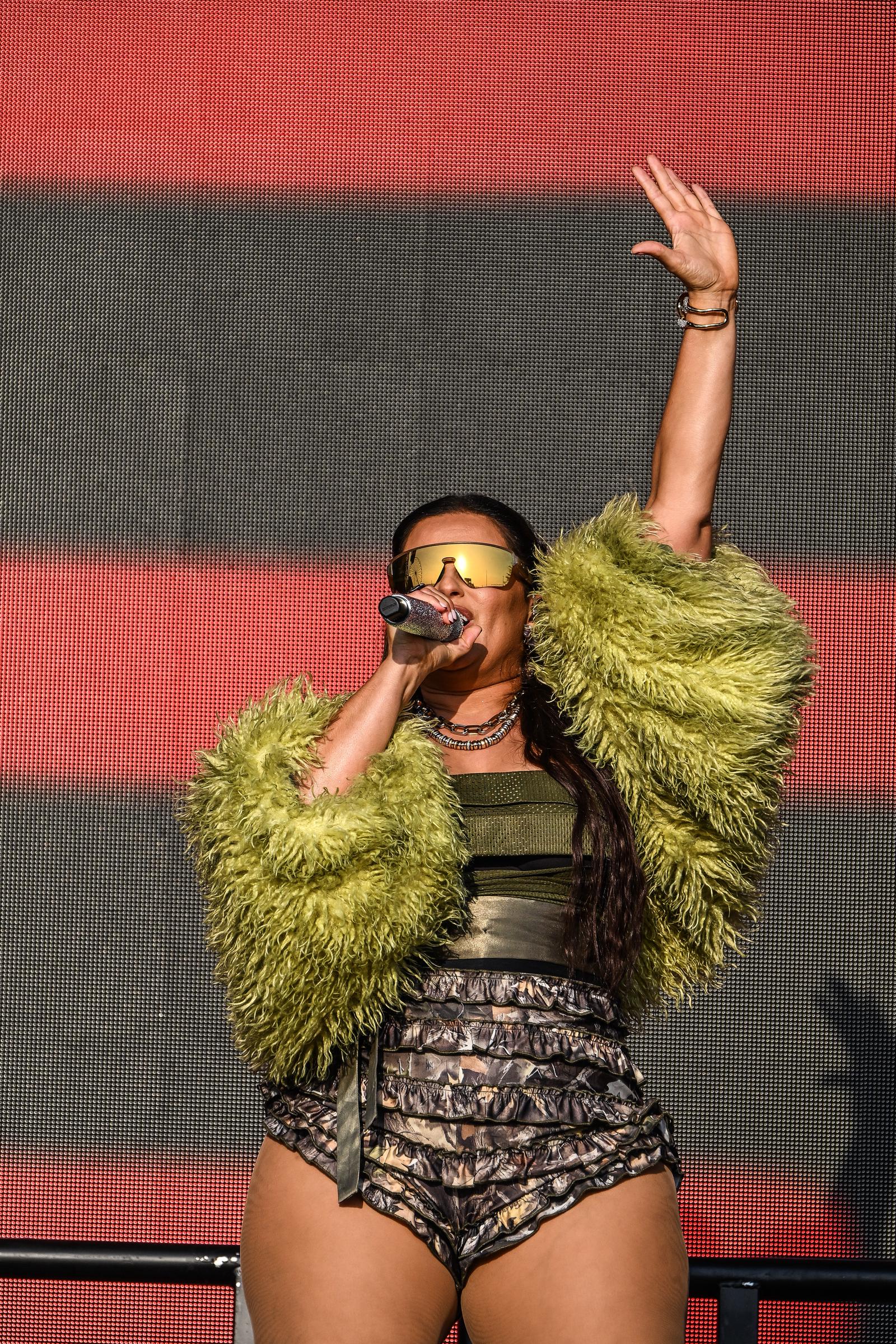 Nelly Furtado makes a bold statement in ruffled camo shorts, a metallic bustier, and a shaggy green jacket at the Boardmasters Festival in Newquay, England.