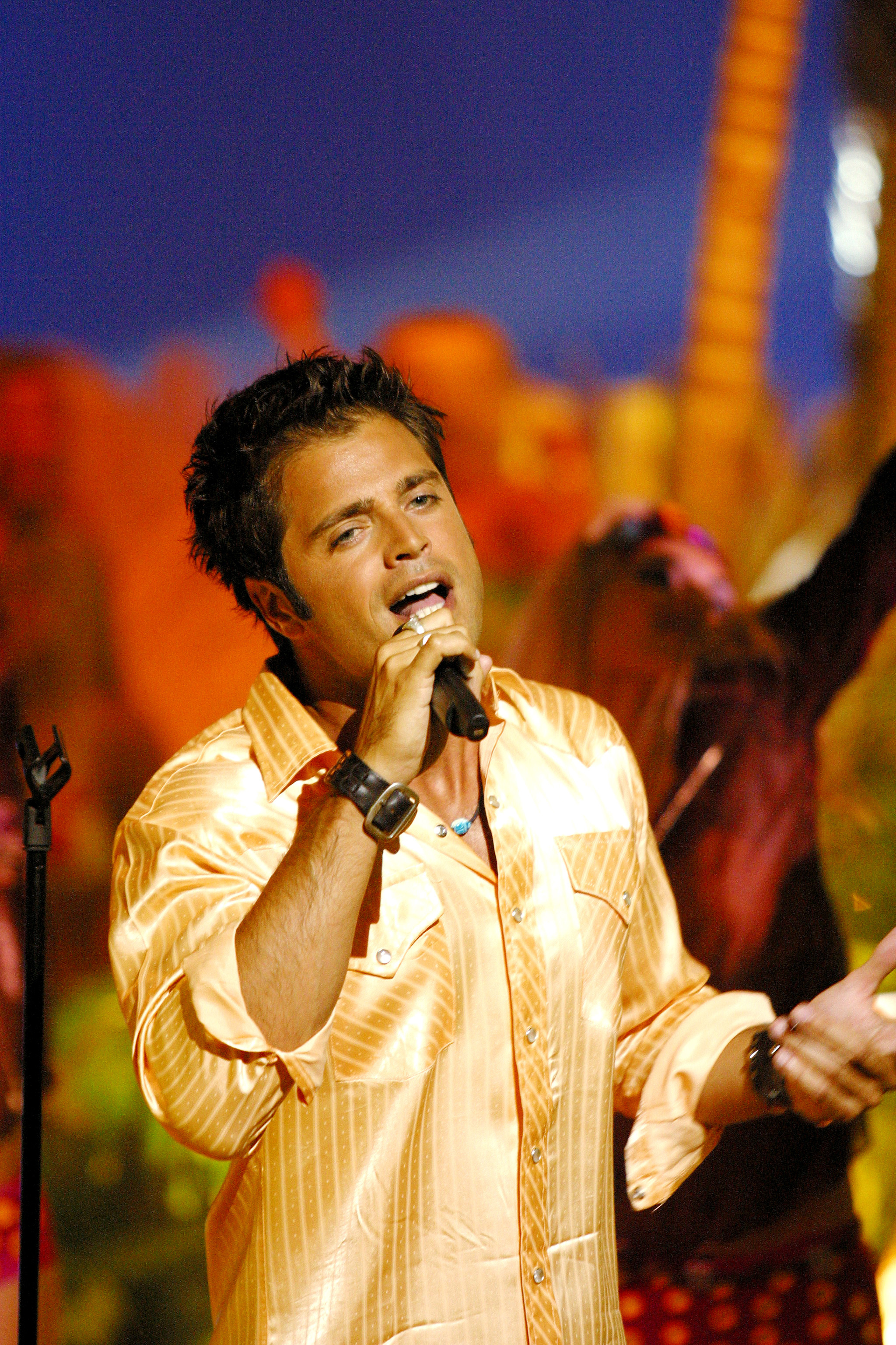 The actor sings on the set of the French T.V. show "Feux de l'ete" on August 1, 2002 | Source: Getty Images