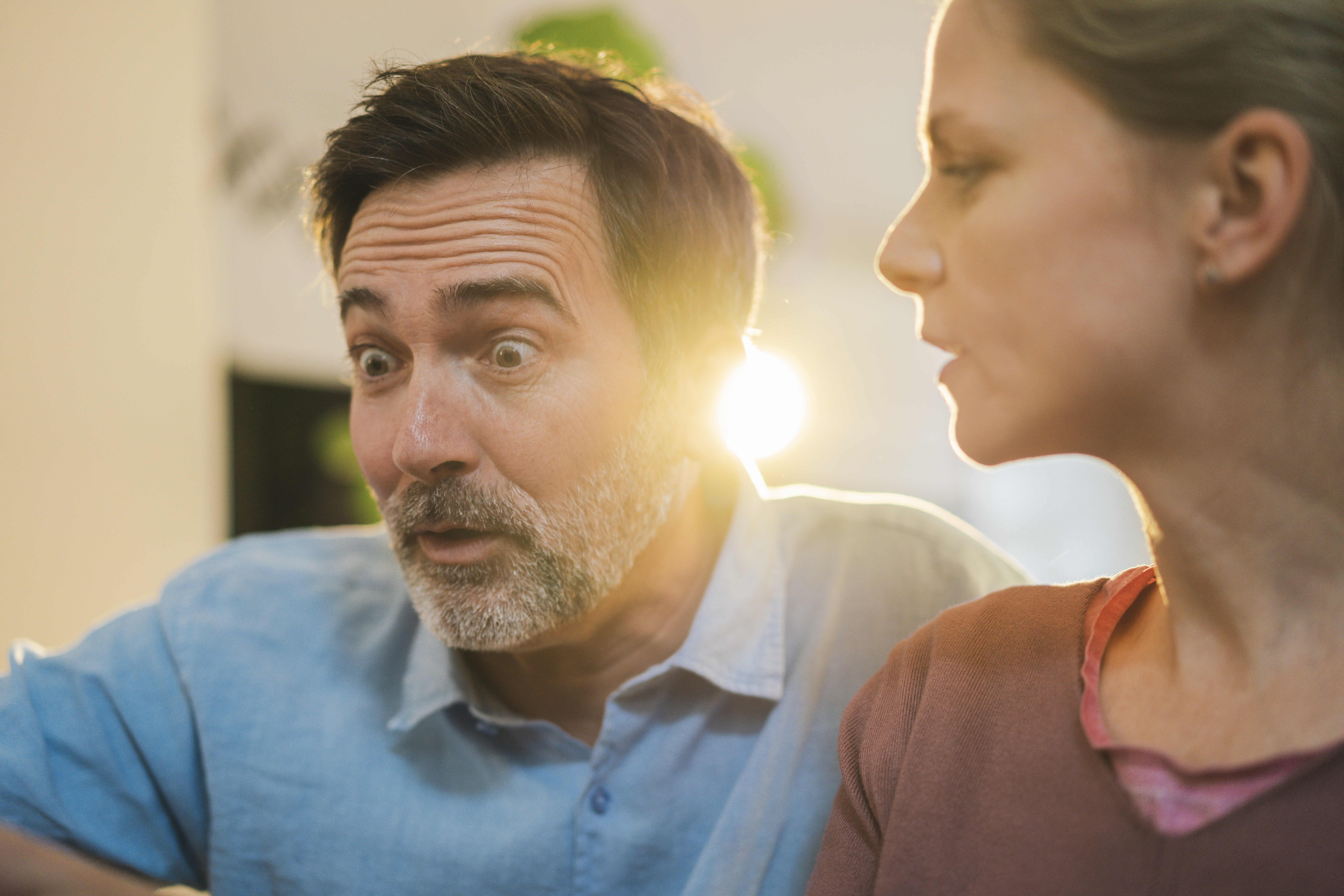 Mature man with raised eyebrows by wife at home | Source: Getty Images