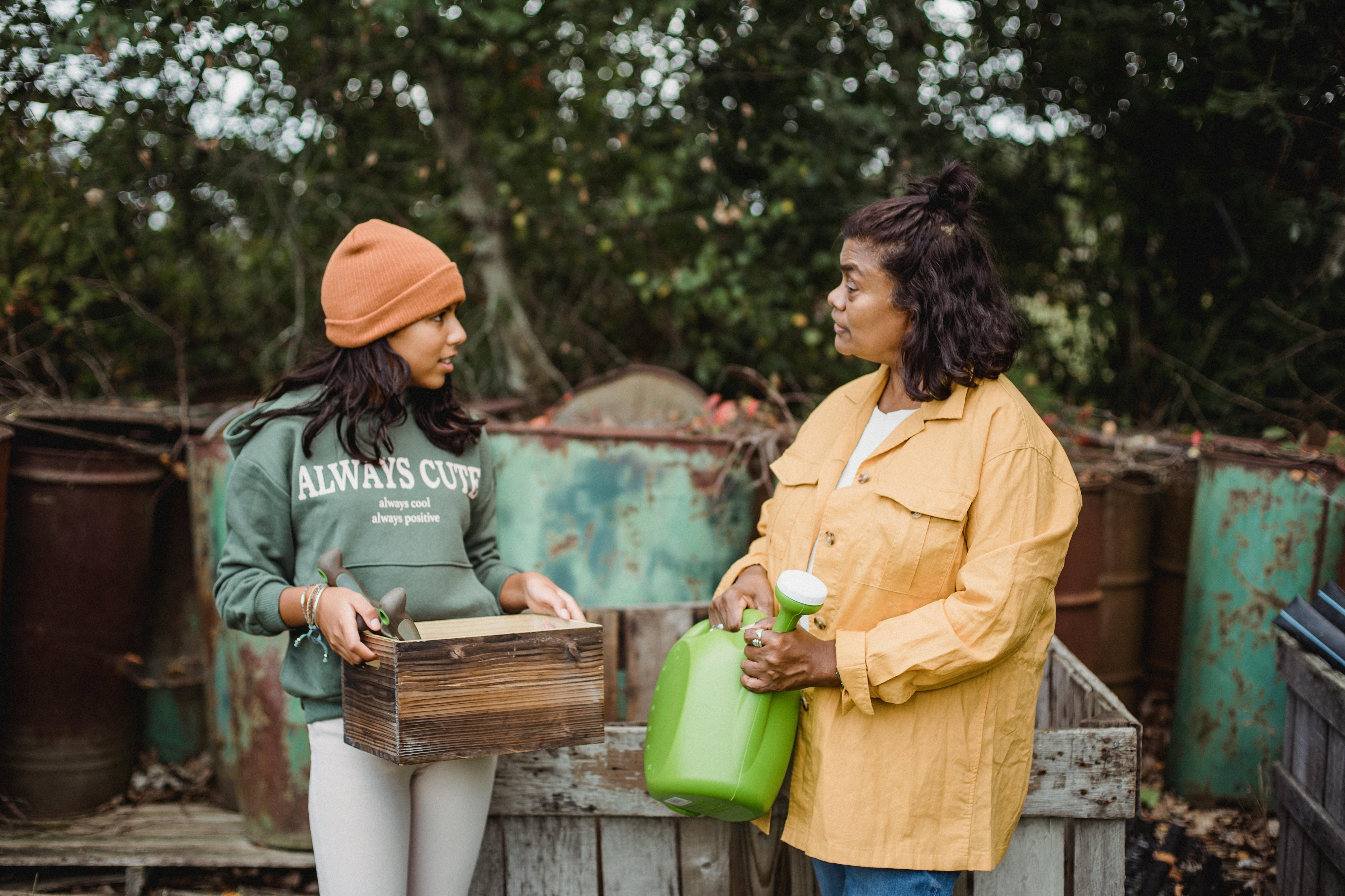 A mother talking to her daughter while carrying gardening tools | Source: Pexels