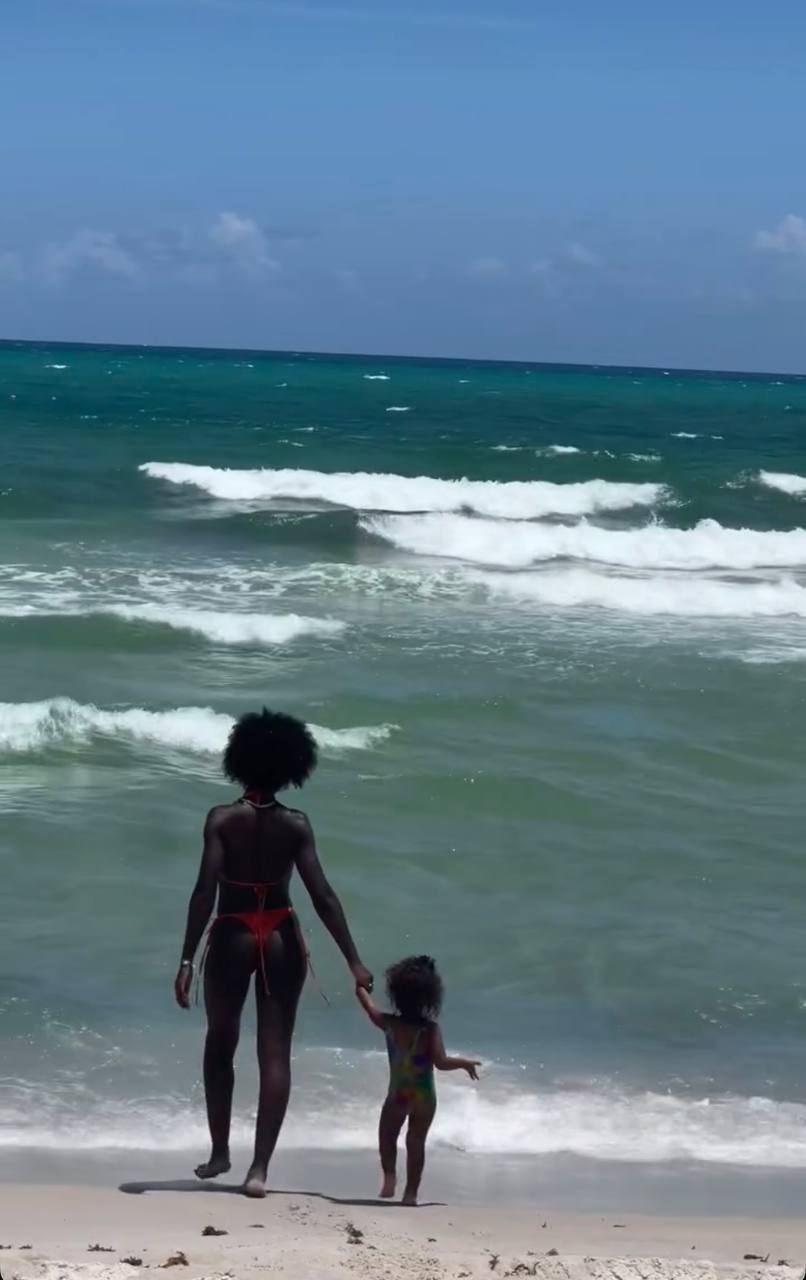 Jodie Turner-Smith and daughter Juno Jackson hold hands at the edge of the ocean during a sun-soaked beach day | Source: Instagram/jodiesmith