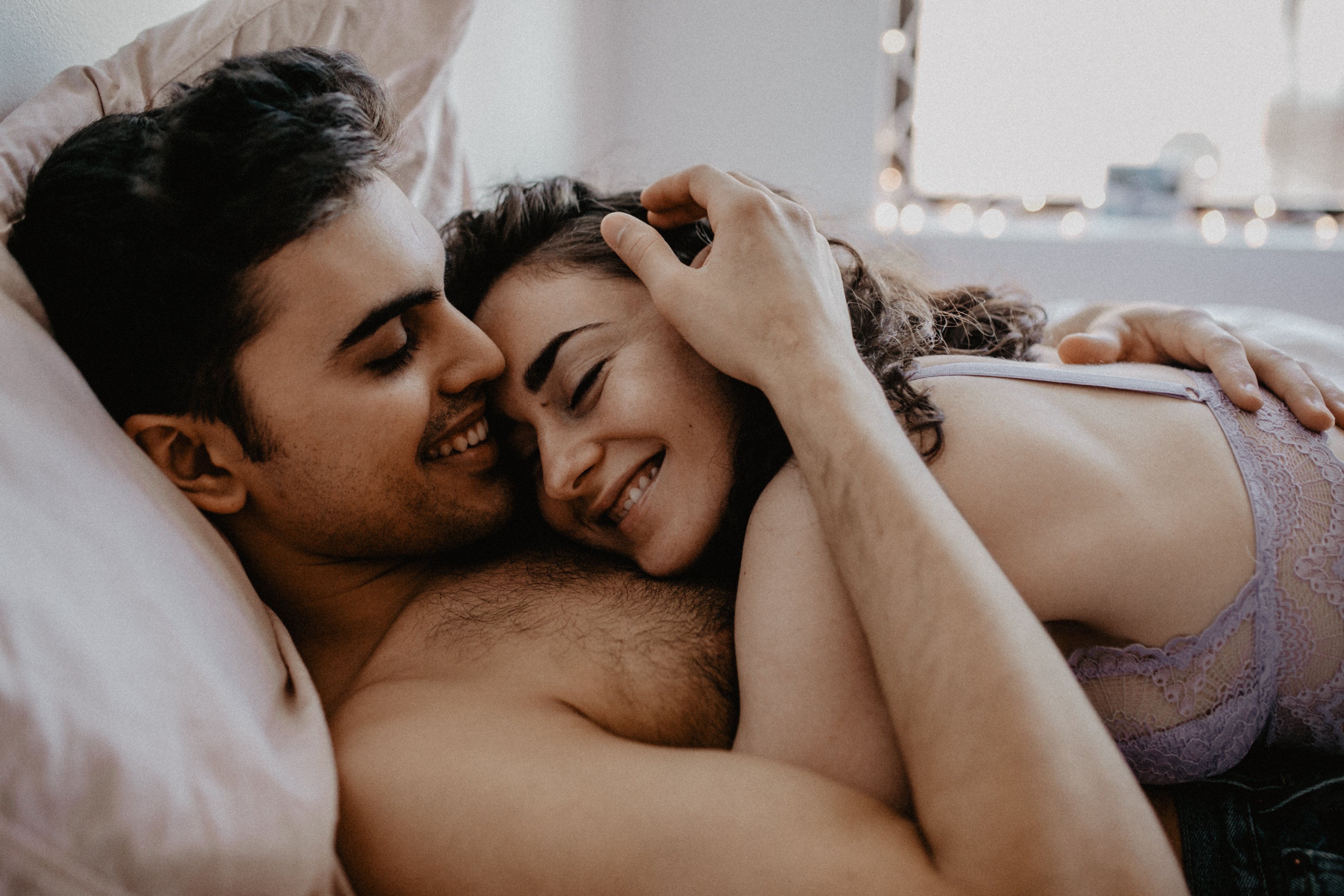 Portrait of happy couple in love, hugging in bed | Photo: Shutterstock.com