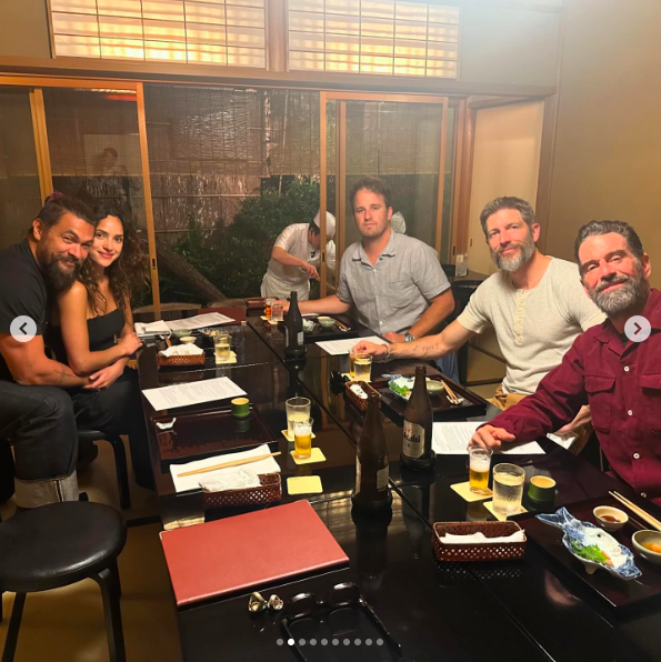Jason Momoa and Adria Arjona with friends, posing for a picture at a restaurant, posted on May 20, 2024 | Source: Instagram/prideofgypsies