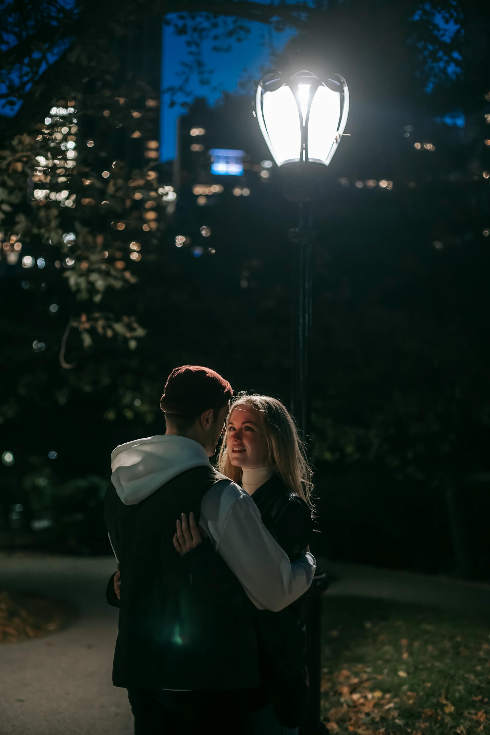 A couple standing under a street lamp | Source: Pexels