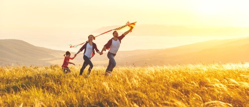 Glückliche Familie im Freien mit Drachen | Quelle: Shutterstock