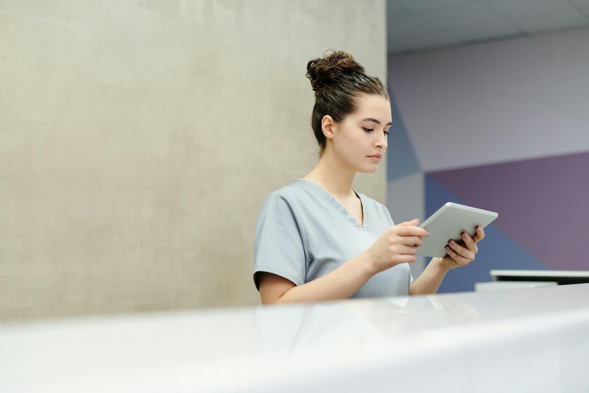 A receptionist holding a tablet | Source: Pexels