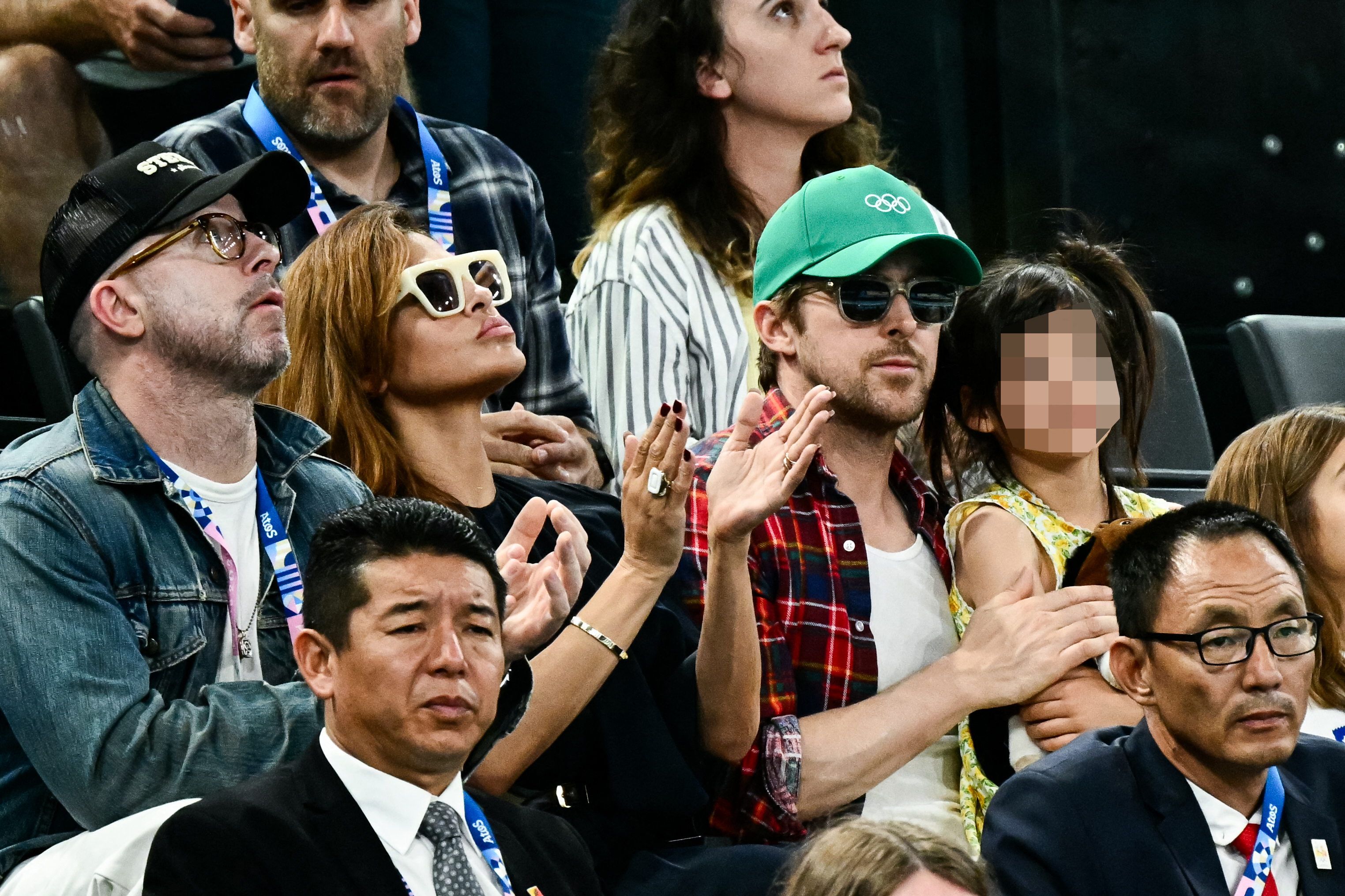 Eva Mendes and Ryan Gosling, with their daughter, watch the women’s uneven bars final at the 2024 Paris Olympics on August 4, 2024 | Source: Getty Images