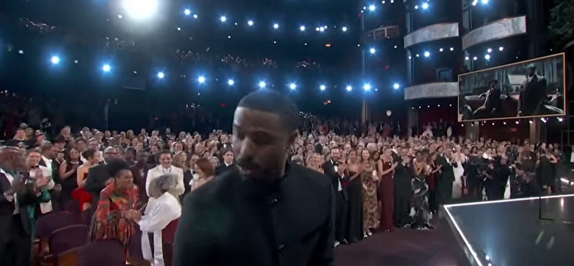 As Michael B. Jordan stepped toward the podium, Donna Jordan remained standing near her seat while people behind her congratulated her. | Source: YouTube/ABCNews